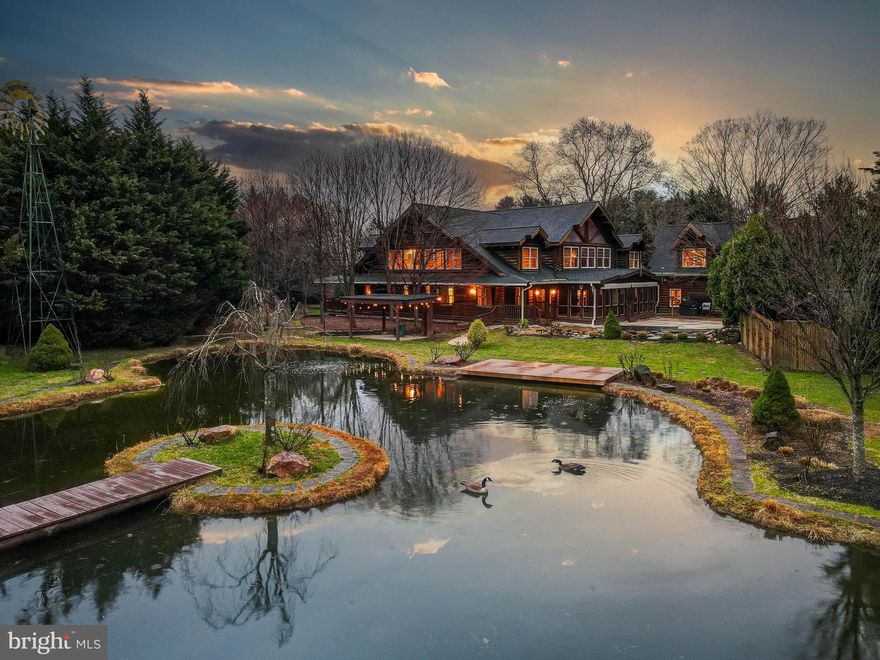 Live authentically. Dover Lodge. A stunning log retreat that brings the Adirondacks to you. A private oasis. This architectural gem is a sanctuary of serenity, offering an unparalleled connection to the outdoors. Upon entering, a magnificent great room with soaring vaulted ceilings and exposed wood beams creates an awe-inspiring gathering space. The stone fireplace serves as a striking centerpiece, radiating warmth and character throughout. Overlooking this space is an elegant catwalk, which encircles the entire great room, offering intimate sitting areas that provide elevated views of the home’s exquisite craftsmanship. Take it all in. The logs provide a strong earthly backdrop. Stamp your design aesthetic. For culinary enthusiasts, the chef’s kitchen is a dream come true. Designed for optimal functionality when entertaining. A spacious butler’s pantry offers additional storage and prep space. Step outside to discover a breathtaking backyard retreat... a dream realized... a wraparound porch and expansive screened-in patio allow you to sip morning coffee while soaking in the sounds of birds and the gentle rustle of leaves. An inviting pool provides a perfect setting for relaxation, while a private tennis court offers a space for friendly competition under the open sky. A tranquil koi pond with a cascading waterfall and covered pavilion invites quiet reflection. Nearby, a picturesque pond with a wooden deck and bridge leads to a secluded island, an enchanting hideaway within your own estate. Further enhancing its charm, a traditional windmill stands gracefully in the yard, completing the idyllic country setting. The entire property is thoughtfully enclosed with both privacy and deer fencing, ensuring both security and protection for your gardening endeavors. Beyond the main residence, practicality meets style in an array of additional outbuildings and infrastructure to house all of your hobbies. The possibilities are endless. A dedicated workshop spanning approximately 1,500 square feet caters to creative pursuits and craftsmanship. Two office spaces allows for the idyllic work from home perch. A dedicated storage shed with a concrete pad ensures functionality without compromising the home’s aesthetic. A stunning fusion of bucolic charm and masterful engineering, tranquility reigns supreme. Minutes to John Brown store, Hunt Valley Town Center and Greenspring Station. Verizon Fios Internet. Cultivate your existence. The art of uniting human and home.