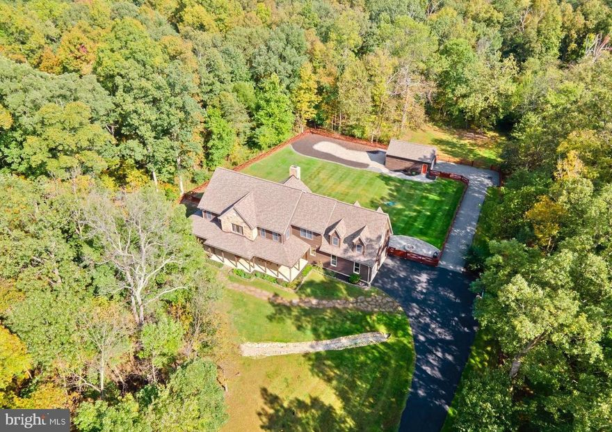 This custom-built craftsman home is a spacious retreat, offering over 6,300 square feet on a secluded 10-acre wooded lot. Nestled at the end of a cul-de-sac, it provides tranquility and privacy. The main level welcomes you with a grand 2-story foyer and a Family Room boasting cathedral ceilings and a striking stone fireplace. The gourmet kitchen features a 6-burner, 2-griddle Viking gas range, top-notch appliances, granite counters with a large center island, and a fresh new backsplash. 

There's also a generously-sized office with custom built-in shelving and a sunroom leading to a private porch patio. Above the garage, discover a versatile bonus room perfect for a reading nook or guest bedroom. Hardwood floors adorn the main and upper levels, while ample windows flood the space with natural light. Upstairs, find 3 spacious bedrooms and a convenient laundry room. The master suite offers a cozy sitting area, walk-in closet with built-in shelving, and a newly remodeled luxury bath boasting a lavish 84" double sink vanity and new tiles. 

The walk-out lower level is an entertainer's dream, featuring a recreation room with stone fireplace, a custom wine cellar with a secret room, a wet bar, a full bed and bath, and an additional bonus room. 

Outside, revel in the closed -in porch, deck, stone patio with firepit, and a luxurious hot tub accommodating 8 people. The beautifully landscaped yard also includes a 3rd detached garage and a fully fenced bonus yard space. 

Recent updates include custom painting, attic insulation, new blinds installation, newer washer/dryer, kitchen backsplash, basement flooring replacement, a new driveway, electrical upgrades, and replacements of interior outlets. Additionally, enjoy peace of mind with a newer roof, water filtration system, septic system, electrical panel box, and backup power generator panel. This home offers ample space and amenities for all your entertaining needs.