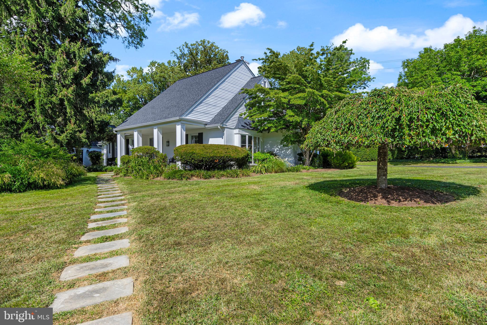 Nestled on a picturesque cul-de-sac among other fine homes, this captivating Cape Cod residence offers a rare blend of classic East Coast charm and relaxed West Coast style. An inviting covered front porch welcomes you into a home designed for both elegant entertaining and comfortable daily life.
A gracious center hall serves as the home's welcoming heart, opening to a formal living room anchored by a handsome gas fireplace. Large picture windows bathe this space and the adjoining formal dining room in natural light. The cozy family room, complete with a second fireplace and a built-in bar create an additional space for relaxation and entertaining . From here, sliding glass doors lead to the home's true showpiece: an expansive and exceptionally private rear patio. With its distinctive perimeter walls, this sun-drenched courtyard feels like an intimate outdoor room, perfect for al fresco dining and quiet relaxation.
The thoughtfully positioned kitchen connects the family room and dining room, offering its own direct access to the patio for seamless indoor-outdoor living. This level also features the highly desirable convenience of a serene primary bedroom retreat, complete with a walk-in closet and a full en suite bathroom. An additional large bedroom and a full hall bath complete the main floor.
The upper level includes two generously sized bedrooms connected by a shared bathroom. A nearby door reveals a vast, unfinished attic space—a blank canvas awaiting your vision, with ample room to create an additional suite, home office, or recreation area. The full basement provides exceptional storage, laundry facilities, and houses the home's mechanical systems.
The exterior grounds are equally impressive, featuring a detached two-car garage and a circular driveway that offers convenient access to Providence Road. The property also includes two thoughtfully designed native meadows, which enhance its natural beauty while providing ecological benefits.
This home’s location is unparalleled, offering easy access to the SEPTA rail line, the vibrant shops and restaurants of downtown Media, and the award-winning Wallingford Elementary School just across the street.