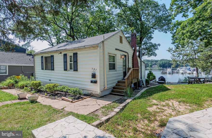 Incredible opportunity to renovate and reimagine your own waterfront retreat on Rock Creek! This 1-bedroom, 1-bath cottage offers stunning water views and approximately 40 feet of waterfront with a spacious deck—perfect for relaxing and enjoying the peaceful setting. A small pier is already in place and may be extended into deeper water with county approval. Inside, you'll find a great room with fireplace, a sunroom, and a functional kitchen. Built-in storage on the water side adds convenience, and off-street parking is available via a gravel/dirt drive. The home needs a full renovation but offers rare potential in a vibrant waterfront community with amenities that include docks, boat storage, beach access, and a clubhouse just a few houses away. This cooperative requires Board approval, owner-occupancy, and may limit some financing options -documents are available online. Located close to the new library, shopping, dining, BWI, Baltimore, Ft. Meade, and major commuter routes (695, 295, 100).