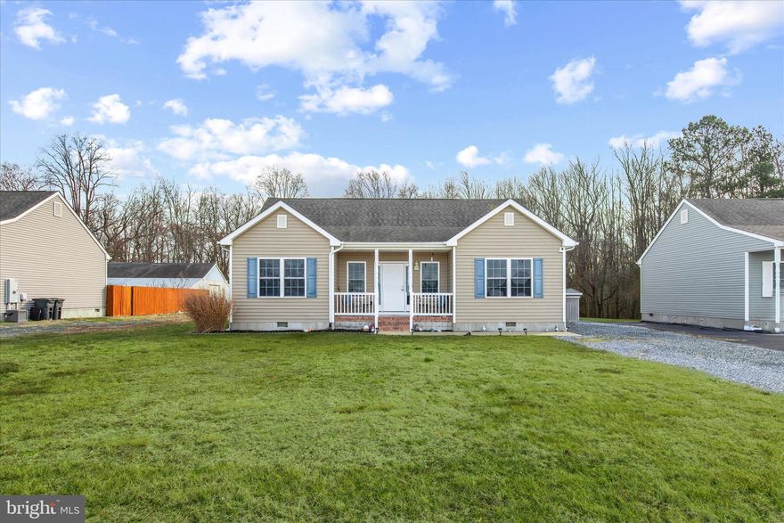 Welcome home to this charming three-bedroom, two-bath home set on a spacious lot, where comfort and easy living come together beautifully. A welcoming covered front porch invites you to slow down and settle in, whether you’re enjoying a quiet morning coffee or gathering with friends at the end of the day. Step inside to a modern open floor plan that seamlessly connects the main living spaces, creating a natural flow ideal for everyday living and relaxed entertaining. The kitchen is a true standout, featuring granite countertops, stainless steel appliances, rich, warm wood cabinetry, a pantry for added storage, and convenient main-level laundry. The kitchen remains open to the dining area and spacious living room, making it easy to stay connected. The primary suite is thoughtfully tucked away on its own side of the home, offering privacy along with an en suite bath, ceiling fan, and plush carpeting for a comfortable retreat. Two additional bedrooms are nicely sized and share a full hall bath, perfect for family, guests, or a flexible bonus space. Just off the kitchen, a rear deck overlooks the expansive backyard, providing plenty of room to play, garden, or host summer barbecues under the open sky.  Off-street parking in the driveway adds everyday convenience. Ideally located in Delmar, Maryland, this home offers easy access to commuter routes and is just minutes from Salisbury, allowing you to enjoy both small-town charm and nearby shopping, dining, and amenities.