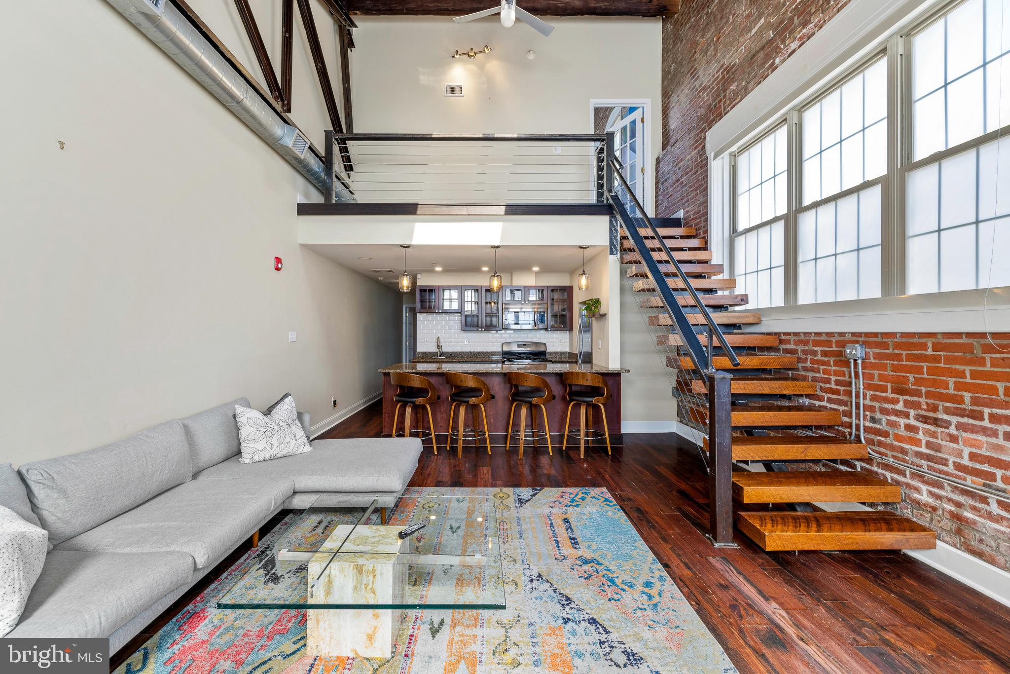 The epitome of Fishtown living, 1301 N Front St. has all the ingredients to fully experience this chic and desirable locale. This two bedroom two bath bil-level with central heat and air has everything you need and everything your friends will be jealous of! The open-concept living/kitchen area features 20+ ft vaulted ceilings with an industrial steel rafter, hardwood floors, exposed brick, a floating staircase, and skylights that let the natural light pour in. The kitchen boasts stainless steel appliances, granite countertops, subway tile backsplash, and a peninsula with seating for 4. Continuing on, the first floor is completed by a dedicated laundry room, a full bath with jacuzzi tub, and the large main-floor rear bedroom with loads of closet space. Ascending the stairs, the second floor begins with a bonus space overlooking the living room, perfect for a workspace, an additional seating area, or home office. The second large bedroom features a custom reclaimed wood partition, behind which a custom closet and shelving solution is neatly hidden. The en suite bath is bathed in light thanks to the oversized skylight and features beautiful black pebble flooring that continues into and up the walls of the large stall shower. The real scene stealer of this shiek and truly unique design is the aforementioned steel rafter that runs through the wall, along behind the mirror and vanity, and finally into the shower! Last but certainly not least is perhaps the most valuable asset in the neighborhood- PARKING! You can park your vehicle, off-street, right outside the door. Which is a good thing, ‘cos you won’t really need it!! With a walk score of 99 (!) you could not be more in the heart of it all. Restaurants, bars, coffee shops, boutiques, groceries, goodies, and mass transit- all at your fingertips!