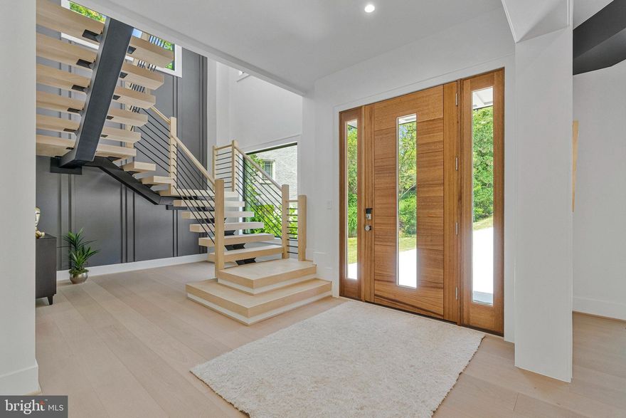 PRICE IMPROVED! Modern Elegance Meets Resort-Style Living in the Heart of McLean
Nestled on a rare, flat 31,533 sq ft lot in a quiet McLean enclave, this architecturally striking residence blends modern design with resort-style amenities. The expansive, level grounds are ideal for a future pool or a game of soccer, easily watched from the comfort of the screened porch—perfect for family living and entertaining.
Backing to a tranquil creek and lush wooded views, the property offers exceptional privacy and a serene natural setting. A sleek stucco façade, expansive glass windows and doors, and a spacious three-car garage create impressive curb appeal.
Inside, soaring 10-foot ceilings on all levels enhance the home’s open, airy atmosphere. Luxurious finishes include 10-inch wide pre finished oak hardwood floors, solid 8-foot modern doors, and exotic designer lighting throughout. The open-concept layout flows seamlessly into a dramatic family room featuring a floor-to-ceiling linear gas fireplace, and a large screened porch with metal-framed screens and a gas fireplace—ideal for year-round entertaining.
The primary suite is a private sanctuary, complete with its own gas fireplace, a Juliet balcony, and a secluded terrace overlooking the scenic backyard. Whether you're sipping morning tea or enjoying a quiet evening read, the peaceful natural surroundings are always in view. The ensuite bathroom is a modern masterpiece, featuring heated floors, elegant finishes, and spa-like comfort.
Each additional bedroom on the upper level is ensuite, offering exceptional privacy and comfort for family or guests. Every room includes custom walk-in closets, marble-topped vanities, and beautifully tiled bathrooms that reflect timeless elegance and quality craftsmanship.
The fully finished, walk-out lower level continues the home’s luxurious feel with high ceilings, large windows, and abundant natural light. At the center is an expansive recreation room with a custom wet bar, rich wood paneling, ambient lighting, and a cozy stone fireplace. A state-of-the-art media room with tiered seating provides a true cinematic experience, while a dedicated exercise room with access to a full bath offers flexibility for workouts or guest accommodations.
Located just minutes from downtown McLean, top-rated schools, premier shopping, dining, and major commuter routes, this residence offers a rare combination of luxury, livability, and convenience.