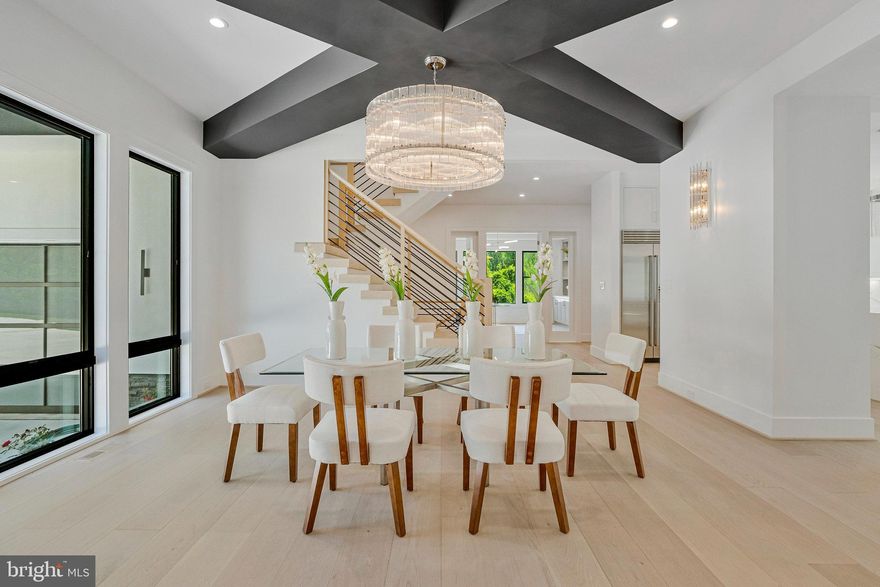 Modern Elegance Meets Resort-Style Living in the Heart of McLean
Nestled on a rare, flat 31,533 sq ft lot in a quiet McLean enclave, this architecturally striking residence blends modern design with resort-style amenities. The expansive, level grounds are ideal for a future pool or a game of soccer, easily watched from the comfort of the screened porch—perfect for family living and entertaining.
Backing to a tranquil creek and lush wooded views, the property offers exceptional privacy and a serene natural setting. A sleek stucco façade, expansive glass windows and doors, and a spacious three-car garage create impressive curb appeal.
Inside, soaring 10-foot ceilings on all levels enhance the home’s open, airy atmosphere. Luxurious finishes include 10-inch wide pre finished oak hardwood floors, solid 8-foot modern doors, and exotic designer lighting throughout. The open-concept layout flows seamlessly into a dramatic family room featuring a floor-to-ceiling linear gas fireplace, and a large screened porch with metal-framed screens and a gas fireplace—ideal for year-round entertaining.
The primary suite is a private sanctuary, complete with its own gas fireplace, a Juliet balcony, and a secluded terrace overlooking the scenic backyard. Whether you're sipping morning tea or enjoying a quiet evening read, the peaceful natural surroundings are always in view. The ensuite bathroom is a modern masterpiece, featuring heated floors, elegant finishes, and spa-like comfort.
Each additional bedroom on the upper level is ensuite, offering exceptional privacy and comfort for family or guests. Every room includes custom walk-in closets, marble-topped vanities, and beautifully tiled bathrooms that reflect timeless elegance and quality craftsmanship.
The fully finished, walk-out lower level continues the home’s luxurious feel with high ceilings, large windows, and abundant natural light. At the center is an expansive recreation room with a custom wet bar, rich wood paneling, ambient lighting, and a cozy stone fireplace. A state-of-the-art media room with tiered seating provides a true cinematic experience, while a dedicated exercise room with access to a full bath offers flexibility for workouts or guest accommodations.
Located just minutes from downtown McLean, top-rated schools, premier shopping, dining, and major commuter routes, this residence offers a rare combination of luxury, livability, and convenience.