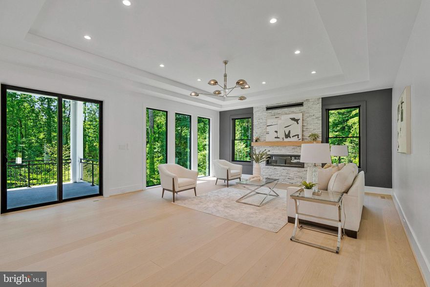 PRICE IMPROVED! Modern Elegance Meets Resort-Style Living in the Heart of McLean
Nestled on a rare, flat 31,533 sq ft lot in a quiet McLean enclave, this architecturally striking residence blends modern design with resort-style amenities. The expansive, level grounds are ideal for a future pool or a game of soccer, easily watched from the comfort of the screened porch—perfect for family living and entertaining.
Backing to a tranquil creek and lush wooded views, the property offers exceptional privacy and a serene natural setting. A sleek stucco façade, expansive glass windows and doors, and a spacious three-car garage create impressive curb appeal.
Inside, soaring 10-foot ceilings on all levels enhance the home’s open, airy atmosphere. Luxurious finishes include 10-inch wide pre finished oak hardwood floors, solid 8-foot modern doors, and exotic designer lighting throughout. The open-concept layout flows seamlessly into a dramatic family room featuring a floor-to-ceiling linear gas fireplace, and a large screened porch with metal-framed screens and a gas fireplace—ideal for year-round entertaining.
The primary suite is a private sanctuary, complete with its own gas fireplace, a Juliet balcony, and a secluded terrace overlooking the scenic backyard. Whether you're sipping morning tea or enjoying a quiet evening read, the peaceful natural surroundings are always in view. The ensuite bathroom is a modern masterpiece, featuring heated floors, elegant finishes, and spa-like comfort.
Each additional bedroom on the upper level is ensuite, offering exceptional privacy and comfort for family or guests. Every room includes custom walk-in closets, marble-topped vanities, and beautifully tiled bathrooms that reflect timeless elegance and quality craftsmanship.
The fully finished, walk-out lower level continues the home’s luxurious feel with high ceilings, large windows, and abundant natural light. At the center is an expansive recreation room with a custom wet bar, rich wood paneling, ambient lighting, and a cozy stone fireplace. A state-of-the-art media room with tiered seating provides a true cinematic experience, while a dedicated exercise room with access to a full bath offers flexibility for workouts or guest accommodations.
Located just minutes from downtown McLean, top-rated schools, premier shopping, dining, and major commuter routes, this residence offers a rare combination of luxury, livability, and convenience.