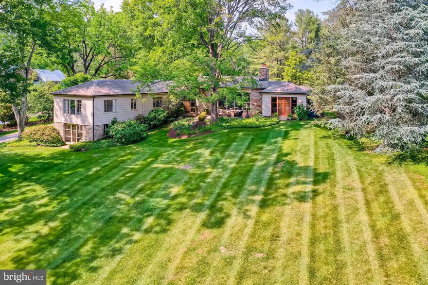 Stunning modern stone retreat on 2.6 acres surrounded by lush landscape and rolling green offers privacy, natural beauty, and recreation poolside or on the court. Designed and constructed mid-century for renowned Baltimore ship builder, design elements include clean lines, open flow, gentle organic curves, impressive mahogany cabinetry and doors, riff-cut wide-plank oak flooring, and an abundance of natural light with remarkable views from every window. Owners have recently completed an exquisite renovation of formal and casual spaces with fine finishes and elegant fixtures in harmony with the enduring architectural style of the residence. Construction highlights include the updated garage, new butler's pantry and kitchen with 8-burner range and 16 ft long marble-slab island, new laundry, kitchen powder room and mud room, new deluxe owners' wing with luxurious bath, walk-in closet, and study. Savor peaceful moments on one of the expansive terraces surrounded by lavender gardens or walk together on the path to kayak on Lake Roland - a 500 acre nature preserve with trails, dog park and nature center. Enjoy the convenience of the neighborhood village with boutique shops, restaurants, a great bookstore, and the Metro Station - just minutes to the Best of Baltimore.