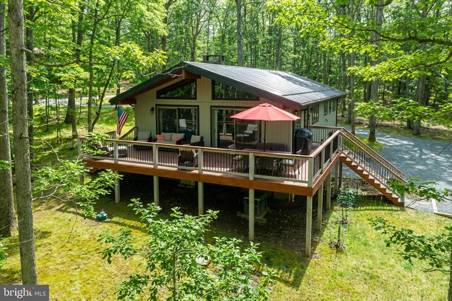 Charming home nestled in the southern end of Deep Creek Lake in the Sky Valley community. Located on a quiet circle, this property offers a peaceful setting while still being close to everything DCL has to offer. With 3 bedrooms, 2 baths, vaulted/beamed ceilings, and an open floorplan, your guests will find comfort and relaxation in this cozy chalet. The kitchen/dining/living areas flow together nicely and provide great natural lighting. Stay warm on chilly winter evenings with the stone gas fireplace in the living room, and walk right out to grill dinners on the deck via one of the sliding doors in the LR/DR areas.  Integrated 1-car attached garage and shed offer nice parking and storage areas. And the spacious deck and yard are ideal spaces for entertaining. The lower level provides additional living area with a family/workout room and a large den. The Sky Valley community amenities include an expansive lakefront area, private beach with swim platform, playground, community docks, boat launch ramp, community fishing pond, and picnic areas. Use your golf cart or ATV for quick access to the waterfront area.  Surrounded by natural beauty, this property offers the perfect balance of privacy and accessibility, making it an excellent base for enjoying lake life, outdoor adventures, or quiet evenings at home.