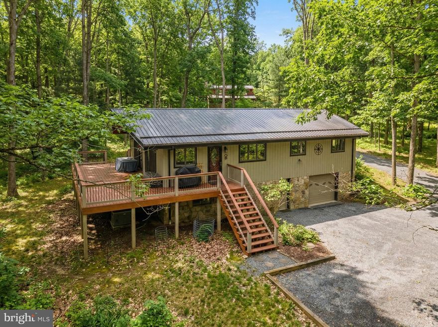 Charming home nestled in the southern end of Deep Creek Lake in the Sky Valley community. Located on a quiet circle, this property offers a peaceful setting while still being close to everything DCL has to offer. With 3 bedrooms, 2 baths, vaulted/beamed ceilings, and an open floorplan, your guests will find comfort and relaxation in this cozy chalet. The kitchen/dining/living areas flow together nicely and provide great natural lighting. Stay warm on chilly winter evenings with the stone gas fireplace in the living room, and walk right out to grill dinners on the deck via one of the sliding doors in the LR/DR areas.  Integrated 1-car attached garage and shed offer nice parking and storage areas. And the spacious deck and yard are ideal spaces for entertaining. The lower level provides additional living area with a family/workout room and a large den. The Sky Valley community amenities include an expansive lakefront area, private beach with swim platform, playground, community docks, boat launch ramp, community fishing pond, and picnic areas. Use your golf cart or ATV for quick access to the waterfront area.  Surrounded by natural beauty, this property offers the perfect balance of privacy and accessibility, making it an excellent base for enjoying lake life, outdoor adventures, or quiet evenings at home.