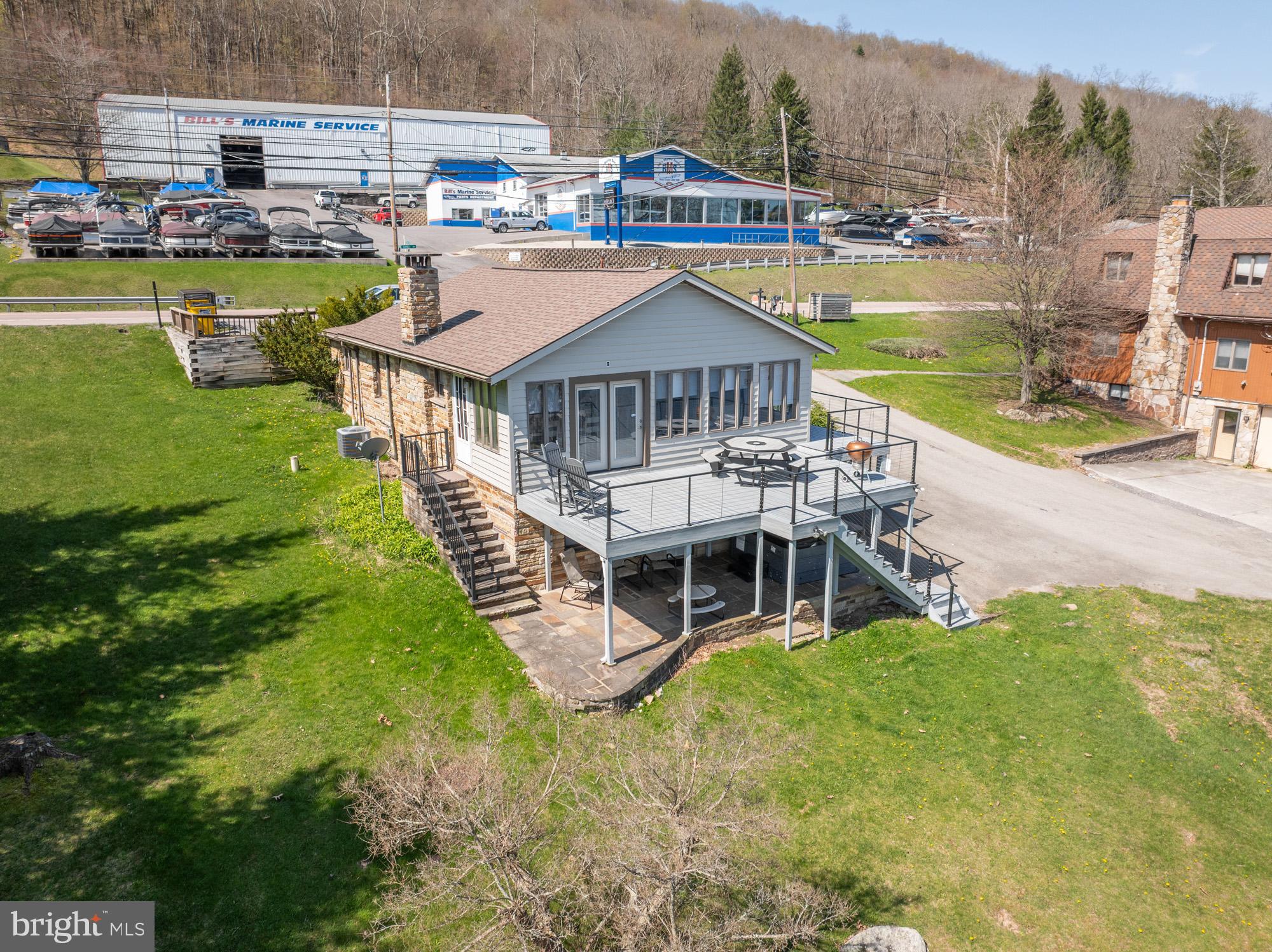 Beautiful lakefront home offering 89' of lakefront and a private dock. This home has been remodeled and is very warm and inviting from the moment you enter. Boasting a great island featuring granite countertops, and plenty of seating for family and friends. The lakefront views are unobstructed year round, and can be enjoyed from most any room. The outside space is just as pleasing with a wrap-around Trex deck, stone patio with a hot tub, and a firepit. If all of this isn't enough, take a few steps down to the lakefront and enjoy the type A dock. The central location is also hard to beat, just minutes to coffee, ice cream, Wisp Ski Resort, grocery stores and restaurants. Established rental "Moments & Memories". Call today to preview!