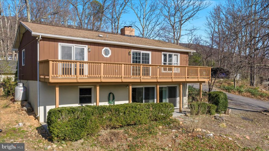 New roof to be installed prior to closing, offering added peace of mind for the next owner.

Welcome to your own private retreat in Shawneeland, where wooded surroundings, community amenities, and flexible living space come together just minutes from Winchester.

Situated on two wooded lots totaling over half an acre, this 4-bedroom, 2.5-bath ranch offers the privacy and natural setting buyers love, with room to spread out across finished living space on both levels.

The main level features comfortable everyday living with two bedrooms, including the primary bedroom, a functional kitchen with updated appliances and ample cabinetry, and inviting living areas anchored by a cozy fireplace. The fully finished lower level provides additional bedrooms, recreation space, and walkout access—ideal for guests, hobbies, work-from-home flexibility, or multi-generational living.

One of the standout features is the expansive deck spanning the rear of the home, offering the perfect space for relaxing, entertaining, or enjoying peaceful wooded views.

Additional highlights include a spacious shed with electricity, generous storage, and a large carport.
As part of the Shawneeland community, enjoy access to amenities including a lake, beach, playgrounds, picnic areas, and recreational spaces—bringing outdoor lifestyle opportunities right to your neighborhood.

Conveniently located just minutes from shopping, dining, and downtown Winchester, this property offers the perfect blend of privacy, convenience, and lifestyle.