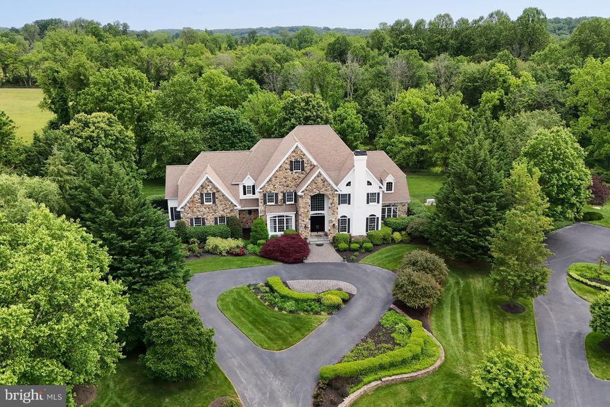 Tucked away at the end of a quiet cul-de-sac in one of Kennett Square’s most coveted neighborhoods, this stately residence offers luxurious living in over 8,400 square feet of space on a beautifully landscaped 1.15-acre lot. With lots of custom changes to the floor plan during original construction, this exceptionally well laid-out home is perfect for sophisticated entertaining, yet is warm, comfortable, and equally perfect for everyday living. The front of the property includes a curved stacked-stone wall, a circular driveway, lush gardens, and stone pavers leading to a grand covered entrance, while the rear of the property includes a newly updated flagstone terrace and a private fenced-in yard. The main level features 10-foot ceilings, newly refinished hard-wood flooring, and a two-story foyer with curved staircase. The gourmet kitchen has a granite island providing seating for four, an angled granite peninsula, tons of cabinet space, and a bright breakfast area overlooking the grounds. Appliances include a 60-inch professional-grade Viking six-burner range with a griddle, two full-size gas ovens, and a range hood; a 48-inch Sub-Zero side-by-side refrigerator; an electric wall oven, microwave, and warming drawer, all by Wolf; and a Bosch dishwasher. Just off the kitchen is an enormous walk-in pantry, a butler’s pantry with built-in cabinetry and granite counter with backsplash, and an elegant dining room with a tray ceiling, wainscoting, arched entrances, columns, and a large picture window. The family room has a vaulted ceiling, marble fireplace, lots of glass, plantation shutters, and a magnificent custom-made, built-in entertainment center. The home has a large private office with French door entry, two double-door closets, built-in shelving and cabinets, and a granite credenza. The main level also includes a bright sunroom with glass on three sides and French doors at both ends, a living room with marble fireplace, and two powder rooms. The upper level has five spacious bedrooms, each with its own full bath. It also has a generous laundry room with counter space, lots of cabinets, and a deep sink. The primary bedroom has a marble entry foyer, tray ceiling, marble fireplace straddled by built-in window seats, and an adjoining sitting room with built-in cabinets, desk, and a television nook. The primary bath has a double glass shower, marble floors, an oversize tub, and an arched picture window with custom wooden shutters. The lower level includes a home theater, a mirrored exercise room, a large recreation room with a built-in TV entertainment center, a powder room, and lots of unfinished storage space. The three-car garage has a newly added beautiful epoxy floor, lots of built-in shelving, and an electric vehicle charger. This home has exceptional millwork and craftsmanship throughout. It is freshly painted, has new carpeting in numerous rooms, and has a monitored alarm system, perimeter flood lights, and a Generac 26 kw automatic power generator that was newly installed in 2024. This impressive Chester County property should not be missed!