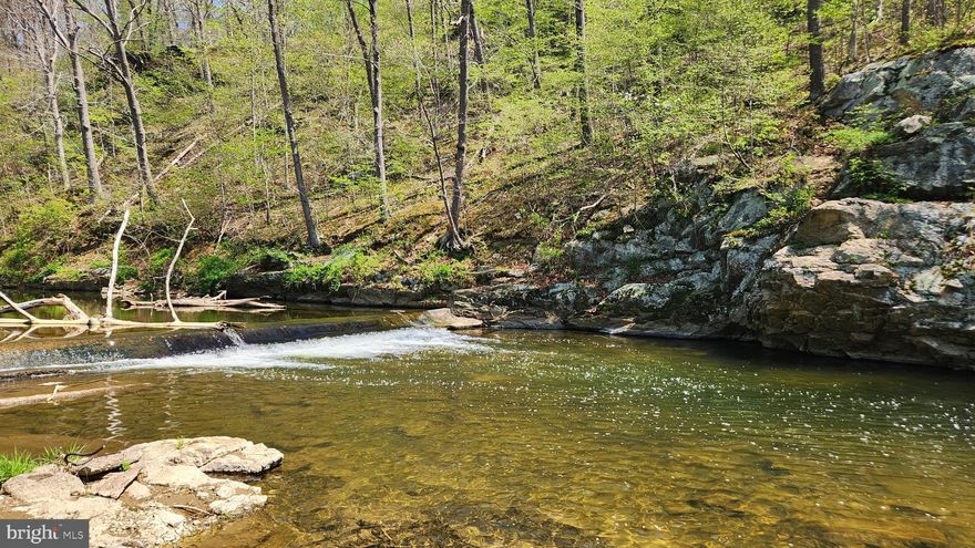 Wow!  How often do you see a reasonably priced parcel with close access and water privileges?  Ever wish you had a place to recreate close to home?  Have you ever wanted to escape from your home and still have a place to go?  This could be it!!   No HOA, you don't even have to mow it!  Just show up and enjoy.  The sound of the water going over the weir is so peaceful and relaxing.  It diminishes the sound of the road traffic on Hwy 17.  There is easy access from the road which provides plenty of parking.  There are stairs down to the water which could use a handrail repair.  But I'm sure you'll have plenty of time for that this summer while you're there enjoying the stream.  Please call the agent, Debbie Hugo, for a personal tour.  It doesn't have an address but it's between and across the street from addresses 7102A and 7020 Burkittsville Road.