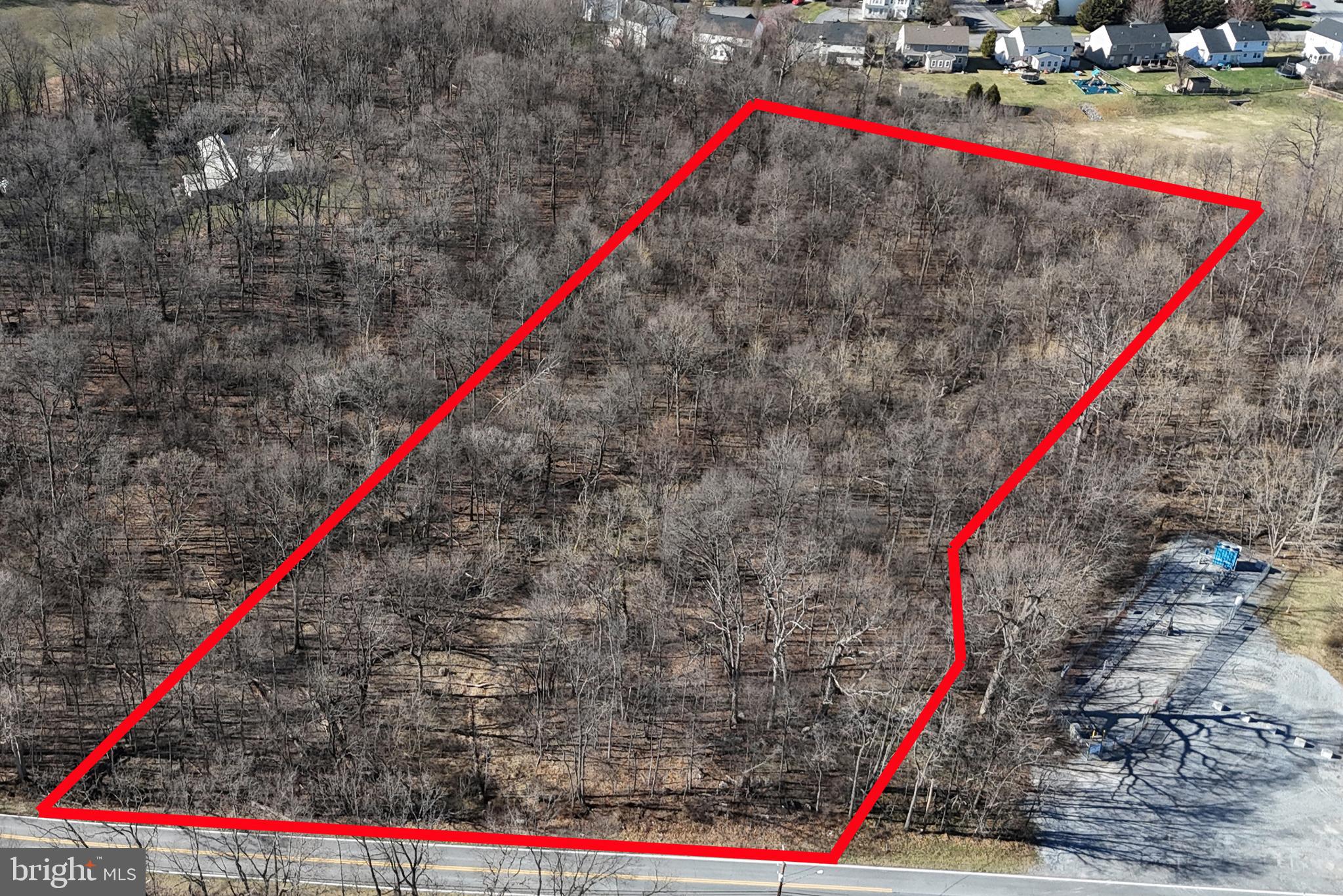 Over 6 acres of flat, wooded land, zoned RT. Cannot be developed due to calculated floor plain (non FEMA) in middle of property however a single family dwelling can be approved and placed in NW corner. Public water and sewer available. Only 1/2 mile from MD Rt. 65 and less than 2 miles to I-70. Approximate front corners have been flagged.