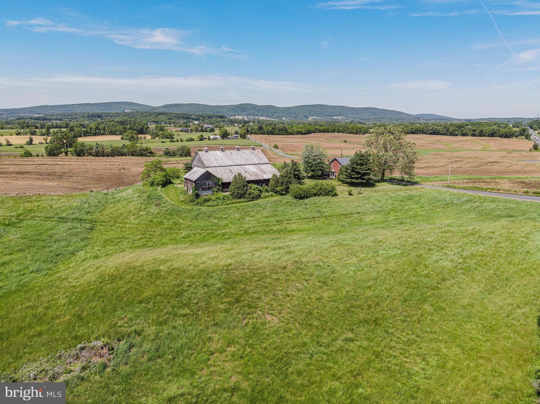 Welcome to your own piece of paradise with stunning views of Pennsylvania's Blue Ridge Mountains! This remarkable property is not preserved and boasts 128 acres of sprawling beauty. Route 15 splits the 128 acres with approximately 28 acres on the east side and 100 acres on the west side. There is substantial truck access to the east and west sides from Route 15. The property is 58 miles from the outer loop (Route 695) of Baltimore MD and 52 miles from Frederick MD. With approximately 115 acres of tillable land, enjoy sweeping views of the mountain range from the 4-bedroom, 2-bathroom brick farmhouse. The property also features an impressive wooden bank barn with a spacious overhang, perfect for agricultural use, storing equipment or hosting memorable gatherings. You're just minutes away from the charming town of York Springs, 20 minutes to historic Gettysburg, and 30 minutes to Harrisburg, ensuring a perfect blend of rural tranquility and urban convenience. Don't miss this opportunity to own a piece of Pennsylvania's picturesque countryside!