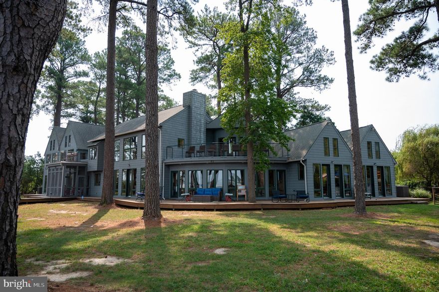 This is the one you have been waiting for!  Welcome to Brannock Pines, an exceptional estate on Maryland’s Eastern Shore that truly has it all.   Sited on 8+ private acres, this home is located in the Neck District of Dorchester County with commanding views of Brannock Bay and beyond to the Western Shore of the Chesapeake Bay.  Architecturally designed and thoughtfully laid out to maximize water views from almost every room in the house.  Extremely rare boardwalks line the waterfront and continue around the house.   Pier w/2 lifts & boat ramp so you can enjoy boating, fishing, kayaking, wind surfing and watching migratory swans, geese, and osprey.  The main house offers an inviting open floor plan with beamed cathedral ceilings throughout and recessed lighting. Curved blue stone entrance foyer to open Dining/Living/Kitchen space separated by large stone veneer fireplace built from Potomac River stones. Beautiful hardwood pine floors and pine wood walls throughout.   Recently updated Kitchen features Viking 6 burner gas stove with double ovens, 2 dishwashers, and Stainless-Steel Appliances.   The 1st floor has a primary  en-suite bedroom with separate sitting room, bath with jacuzzi & steam shower. This Primary Suite flows nicely outside to a deck area with heated 40X20  gunite/ saltwater pool and hot tub with water views.  On the other side of the home, the guest wing has 2 additional bedrooms with walk-in closets and full baths. There is a beautiful staircase to the second level (plus two spiral staircases for access to the 2nd level).  On the 2nd level you will find an open office area, 2 additional large bedrooms, two balconies w/water views, and a bonus room that could be used for an exercise room or additional storage.  The exterior features well-manicured grounds with lush landscaping that creates a park like setting.  Enjoy the versatile screened in porch overlooking the water that is the ideal place to enjoy your crabs!  Over the 3-car garage is a proper guest residence equipped with Living room, kitchenette, bedroom, bathroom, loft, and screened in area.   Other notable features of the property include a delightful garden shed, outdoor shower, and modern alarm system.   Portion of driveway is shared. The subdivision has birmed infiltration pond septic system (not located on this property). Property has its own tank. There is a $250.00 annual fee from Dorchester County Sanitation Department. Buyer to verify water depth.  This turnkey property comes with all furnishings and is ready immediate occupancy and your quest for Eastern Shore Living!