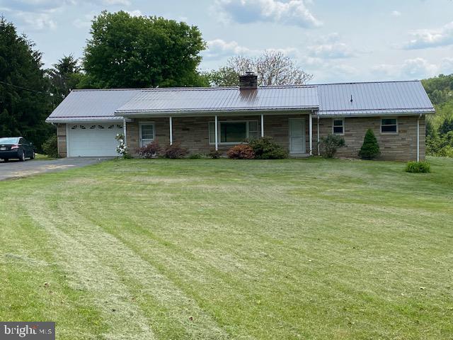 Back on market due to finance issues. This custom built Ohio stone rambler (1568 sq. feet on main level) sits on 2.37 acres fronting on Route 46. The total finished living area is 3136 sq. feet. This property is conveniently located to Fort Ashby and Keyser WV, Cumberland MD, and Allegany Ballistics Laboratory (Northrop Grumman). The house is heated by electric heat pump and has central air. A well provides abundant, excellent water, and there is a spring with a holding tank which is handy for outside watering.
The main level includes a large master bedroom, second bedroom, bathroom with walk-in shower, living room, kitchen/dining room, and laundry room. A two sided, ceiling-high stone fireplace with propane gas logs divides the kitchen/dining area and living room. The laundry room leads to an oversized one car garage with garage door opener and two addition exits to the outside. There are no steps on the main level and all doors are 36 inches wide. This home has a new metal roof installed May 2023.
The lower level (1568 sq feet) can be accessed by stairs which accommodate a stair chair and a private entrance from the outside. It is finished with a full eat-in kitchen, laundry area with storage, living area, bathroom with walk-in shower, recreation area with pool table, and one bedroom and one bonus room with a closet. A wood/coal burning stove in the lower level could heat the entire house.
The outside areas include a covered front porch, a fenced concrete pool in the backyard (not used in recent years), large lawn areas, two sheds, large garden area, mature trees, perennial flower beds, and plenty of room for parking. This property, located in a very desirable area, has so many possibilities. It is a must see.