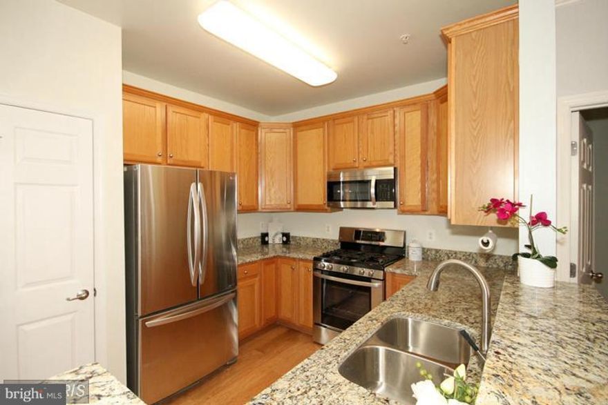 LIGHT-FILLED GARDEN VIEW! 6 foot windows, 10 ft ceilings, 2005 open concept condo. This unit offers two MASTER SUITES with a walk-in closet and second closet in each room. Each suite has its own master bath with updated flooring. The kitchen boasts of 42 inch cabinets and GE appliances. Gas FP, lovely patio, 2 garage parking spots, pool, gym.