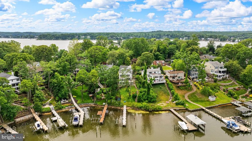 Welcome to a rare waterfront gem tucked away in a secluded, wooded cove in the sought-after Linstead neighborhood, right in the heart of Severna Park, where stunning water views meet timeless coastal elegance. Renovated in 2014 and expanded and enhanced in 2017, this exceptional home offers a seamless blend of luxury, comfort, and stunning vistas at every turn. Step inside to be greeted by panoramic water views when you open the door. The entry landing leads you down a few steps to an expansive living room, bathed in natural light, with a private deck overlooking the water. Adjacent, the gourmet white kitchen flows effortlessly into the sun-drenched dining room, a stunning addition by the owners that enhances both form and function. On this level, you will also find one of the home’s three bedrooms, with en-suite bath, closet space, and access to the clothes washer and dryer. Up a few steps from the entry level, the second floor features an inviting common area with a balcony, mirroring the grandeur of the living room below—perfect for gathering while enjoying sweeping waterfront panoramas. Adjacent is the primary bedroom suite — complete with its own deck overlooking the cove, walk-in closet and en-suite bath. On this floor you will also find a large third bedroom and beautifully designed full bath The top-level expansion introduces two additional rooms, one of which offers captivating water views, while the other features a private balcony. A convenient half bath completes this versatile space, perfect for a home office, studio, or guest quarters. Beyond the elegant interiors, a covered patio area beneath the first floor is an ideal setting for outdoor dining overlooking the water, with overflow space for large gatherings. A storage area on the patio level as reimagined presents endless possibilities—envision a home gym or a one-of-a-kind entertainment space. Viewing the water from each of the three floors and patio, you see a gently cascading slope ending at the water’s edge. In 2024, the owners installed state-of-the-art sediment control fabric and seeding to control soil erosion together and an anchoring system to stabilize the foundation, improvements ensuring that the lovely, elevated vistas from this home remain for years to come. Completing the features of this remarkable property is a shoreline for swimming and kayaking access, coupled with an outdoor shower, a 100-foot pier, and a vertical powered boat lift. Set in the prestigious Linstead community, this home provides easy access to the Severn River, top-rated schools, and the best of waterfront living. Whether you're savoring coffee at sunrise from your balcony or enjoying an evening at sunset looking over the water, this residence offers an unparalleled lifestyle. A truly rare opportunity—schedule your private tour today.