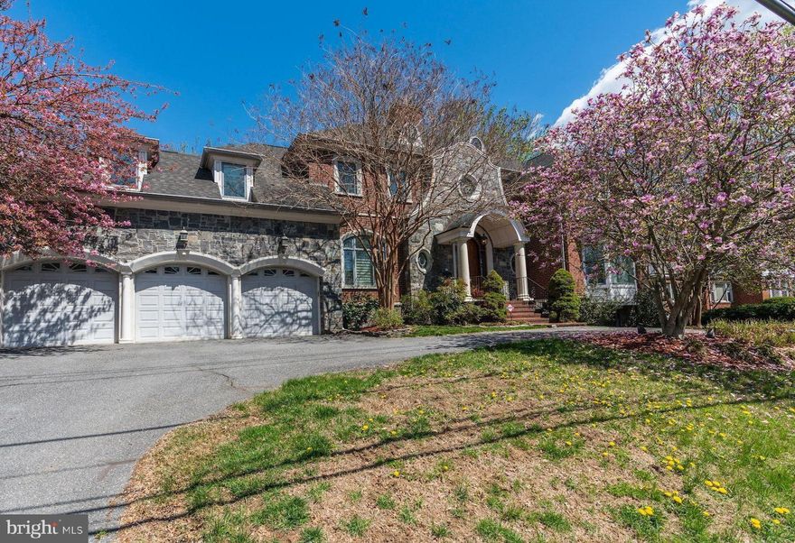 Distinctively designed architectural masterpiece offering over 7,200 sq. ft. of living space on three finished levels, built with exceptional craftsmanship, high-quality materials, and luxury details throughout. This impressive residence features a magnificent granite and stone façade, all-brick construction, thick stone/brick front walls for enhanced soundproofing, high ceilings, and substantial custom main-level doors that are taller and heavier than standard doors. A semi-circular driveway with approximately 10-car capacity leads to a 3-car garage. Interior highlights include hardwood floors, crown molding, boxed ceilings, a main-level library, four fireplaces, double balconies overlooking the beautiful backyard, surround sound speaker system, and an elevator serving multiple levels. The gourmet kitchen features custom cabinetry, granite countertops, a butler’s pantry, top-line appliances, and recently updated kitchen appliances including a brand-new KitchenAid cooktop and newer dishwasher. The main level also includes a guest bedroom suite, ideal for visitors or multi-generational living. The luxurious primary bath includes a jetted tub and heated marble floor. The fully finished lower level offers generous entertaining space with a wet bar. A 2007 addition added an approximately 400 sq. ft. family room with rooftop deck and separate heating and cooling system. Set on a beautifully landscaped 13,700 sq. ft. lot, the property offers a private backyard setting and enhanced front privacy with a row of Green Giant arborvitae trees along the sidewalk. Conveniently located within walking distance to North Chevy Chase Elementary School, golf, NIH, Naval Hospital, and public transportation. Just two blocks from the future Purple Line station and minutes to I-495, I-270, and downtown Washington, DC.