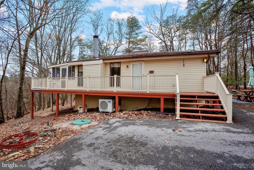 Charming and well-maintained, this home in The Woods Resort offers the perfect blend of comfort, privacy, and convenience—ideal as a full-time residence, weekend escape, or short-term rental. The open layout features vaulted ceilings that enhance the spacious feel of the great room, dining area, and kitchen. A classic wood-burning fireplace with a brick hearth adds warmth and character, while hardwood flooring throughout the main living spaces provides a polished, inviting touch.

Enjoy the seamless connection to nature with an expansive screened porch and adjoining deck, perfect for outdoor dining, quiet mornings, or hosting guests. Recent upgrades include stainless steel kitchen appliances, a stacked washer and dryer, a new storage shed, and an energy-efficient 24K BTU heating/cooling system for year-round comfort.

A thoughtfully designed picnic area with a fire pit creates the perfect outdoor retreat, surrounded by mature trees and frequent wildlife sightings. Located in a quiet section of the resort, yet close to community amenities, this home offers a rare opportunity to enjoy West Virginia’s natural beauty in a well-appointed, move-in-ready setting.

Please note: Sale does not include the optional golf or amenities package offered through Potomac Valley Property.