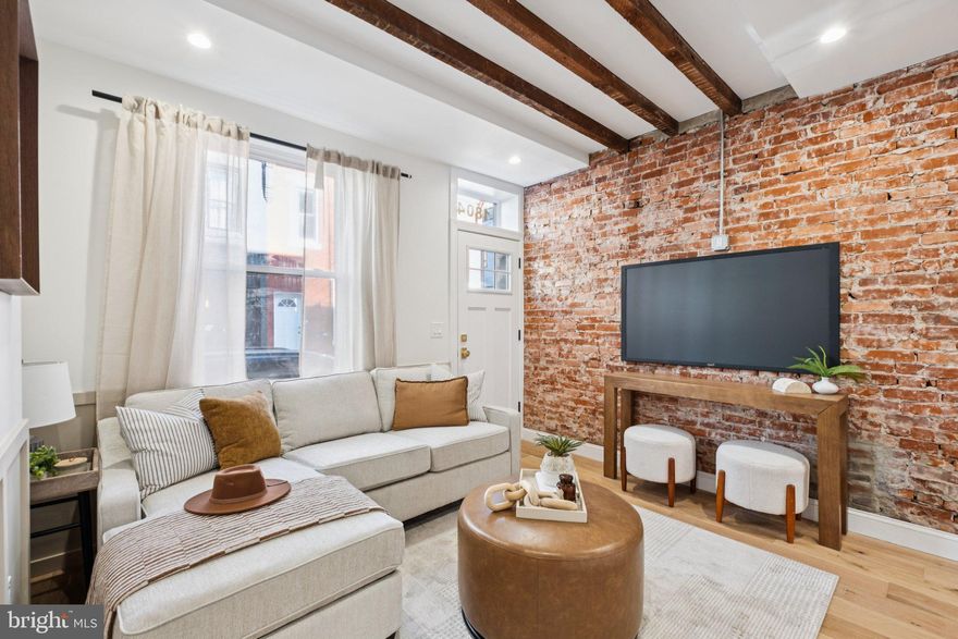 Welcome to 1804 Waterloo Street—a thoughtfully renovated 2-bedroom, 1-bathroom home located in the heart of vibrant Olde Kensington, complete with a 10-Year Tax Abatement. Blending timeless character with modern upgrades, this home offers the perfect mix of historic charm and contemporary style. Inside, you’re greeted by wide plank solid oak hardwood floors, exposed ceiling beams, and abundant exposed brick that bring warmth and texture to every corner. The inviting living area features a custom accent wall with exposed brick, adding depth and visual interest. The chef’s kitchen is as functional as it is beautiful, boasting an extended quartz island, farmhouse sink, shaker-style cabinetry, designer brass hardware, stainless steel appliances, and a custom tile backsplash.  Out back, a private fenced in rear patio offers the perfect space for outdoor dining, gardening, or relaxing under the city lights. Upstairs, you'll find two comfortable bedrooms and a well-appointed full bathroom featuring a tiled tub surround and gold fixtures. The primary bedroom includes an expanded closet and a charming exposed brick accent wall. The unfinished basement provides additional space for a home office, gym, or storage. Enjoy unbeatable walkability to local favorites like Little Susie's Coffee and Pie, Kalaya, and LMNO—plus easy access to I-95 for commuting. This home checks all the boxes and is ready for its next owner. Don’t miss out!