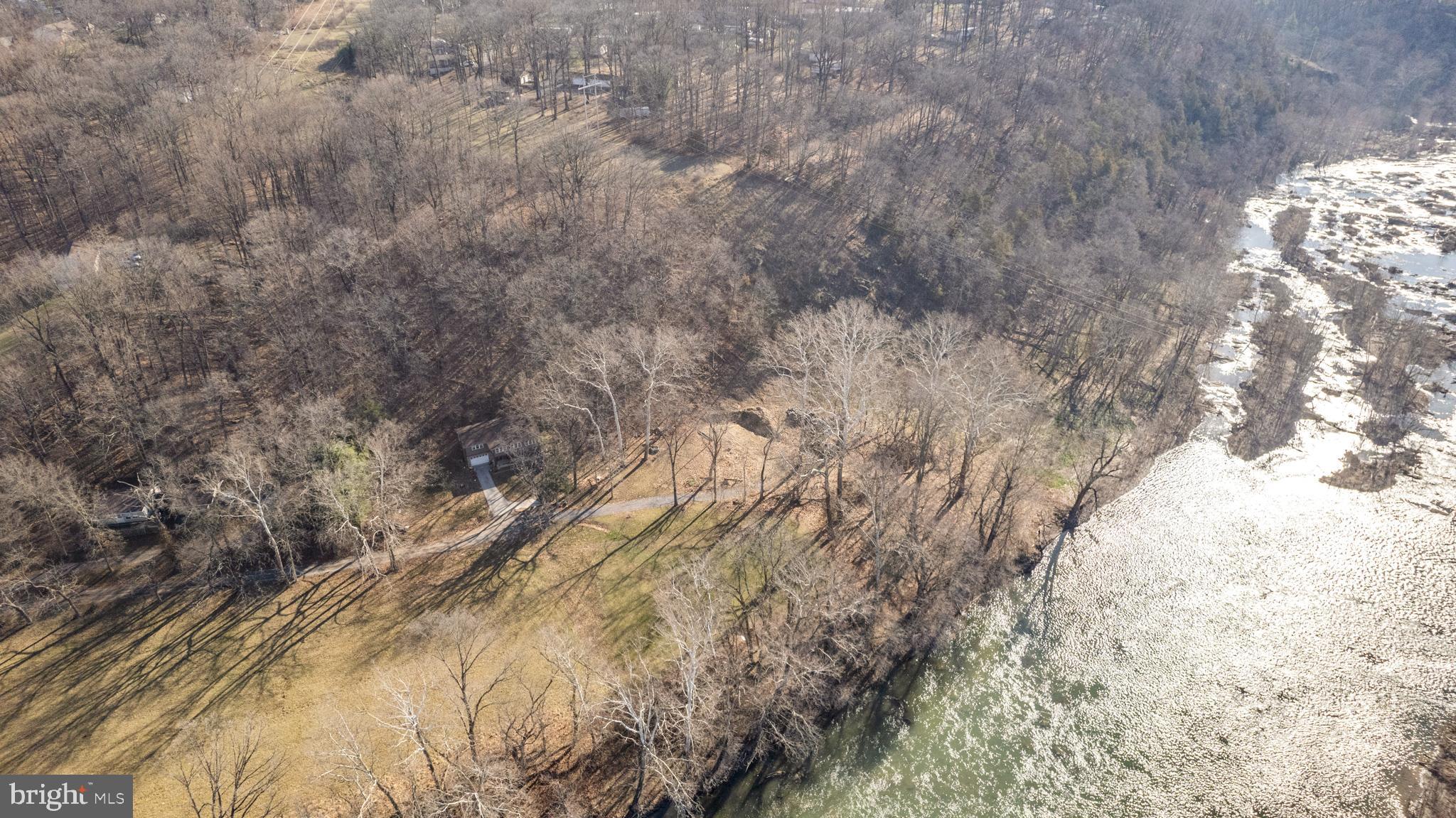 Offers, if any, will be reviewed Monday, 3/11 @ 5pm. Once in a lifetime opportunity to create a dream home on the Shenandoah River. This river front land in Harpers Ferry, WV consists of 2 lots totaling 0.81 acres on the final lot of a gravel road for quiet and privacy among the beautiful giant sycamores. It delivers the perfect spot to put in for tubing, canoeing, kayaking etc. given it is just down river from a small hydroelectric dam. This means you could use the river to get straight to Harpers Ferry Historical National Park. Custom architectural plans have been finalized by DC/WV licensed architecture firm and approved by DC/WV licensed structural engineer. The custom design evokes Scandinavian modern A-frame with the conceptual all black exterior intended to recede into nature like a shadow while creating a warm and inviting interior space. Come build your own beautiful backdrop for your future memories and make it dual purpose by renting it on AirBnB (Jefferson County WV zoning permits short term rentals – see Zoning Ordinance Text Amendment File #ZTA21-01, buyer to verify). The plans create two huge owner's suites on opposite wings of the house along with an office/den making this an excellent configuration for all your needs. The main space is designed to provide soaring ceilings (26') with a wood burning stove and open kitchen / dining area with a screened in porch nearby to enjoy dining al fresco. The front decks are huge and accommodate a separate landing area for a private hot tub. The lower level would serve as a garage / huge storage or recreation room. The gravel road was extended via WVDOT approved plan, the site has been cleared and a brand new (75gal/minute!) Well by Negley's has been installed. The septic permit is also in hand. Everything is squared away such that you could still make any final modifications to the architectural plans before final submission for permit. Whether you're looking to create your dream home on the river or a 2nd home / vacation rental, this property and its design have you covered. There's no HOA and high-speed Xfinity gigabit already serves the adjacent properties.
Please note that if you view the property, the red lines in the pictures help provide a rough approximation of the lot lines such that you can remain on the property when viewing. Please note that the field is not part of the property and the property line starts at roughly the edge of the field, thank you!