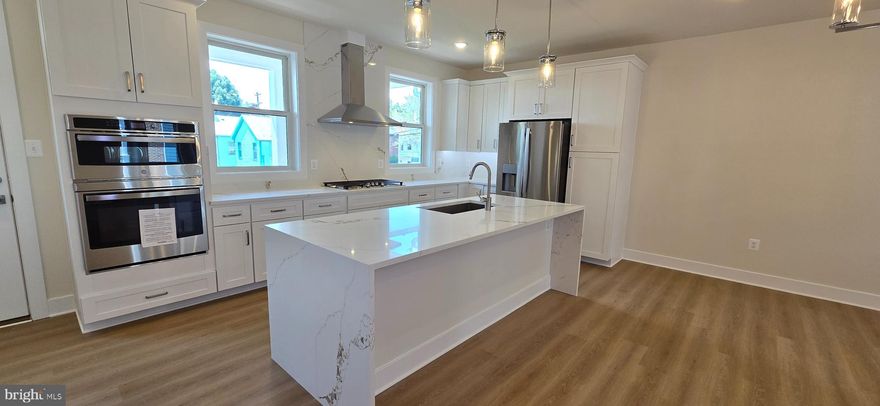 ONE OF A KIND RENTAL — Welcome to Frederick’s newest crown jewel, Chapel Alley! This end-unit, new construction, 3-story townhouse—the largest in Frederick—offers a rare opportunity for luxury living in the heart of picturesque Downtown Frederick, just steps from the city’s best dining, shopping, and entertainment. No detail was overlooked and no expense spared in crafting these one-of-a-kind homes. The striking exterior features red and black brick, composite black casement windows, custom iron railings, galvanized gutters, full divided light doors, and Hardie plank siding. Enjoy two private parking spaces, a fenced backyard, a utility balcony, and professional landscaping. Inside, the open-concept layout is anchored by a chef’s kitchen with natural quartzite stone countertops, a waterfall island, double oven, cooktop, built-in refrigerator with craft ice, and custom cabinetry with glass accents and built-ins—including a dedicated stone-topped kitchen desk. The adjacent dining and family room showcase a dramatic fireplace surround and built-in storage, with a balcony for fresh air just steps away. The primary suite features dual custom closets, a Juliette balcony, and a spa-like bath with natural black stone countertops, a black soaking tub, dual shower heads, and designer lighting. All baths feature floor-to-ceiling designer tile and premium fixtures. The top-level penthouse, with its own mini-split, includes a built-in bar, half bath, and sweeping views. This is Downtown Frederick luxury living at its finest—spacious, stylish, and truly one of a kind.