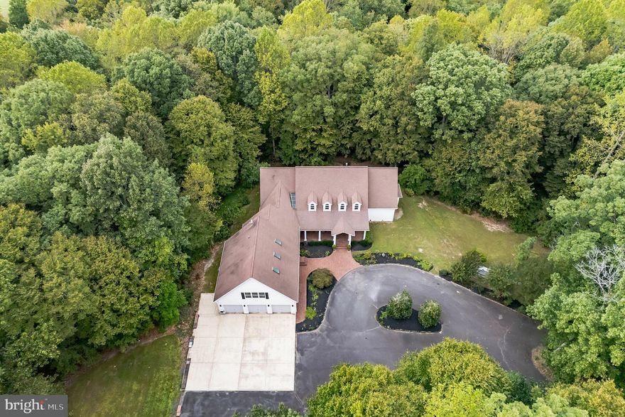 Location meets luxury and privacy in this once in a lifetime forever home. This airy, light-filled home is built for living and life with 10’-20’ ceilings throughout the first floor and banks of windows. The flow of this house is second to none. Entertain year-round in the oversized cook’s kitchen, the great room with gas
fireplace, and on the 16’ x 28’ teak deck. Picture yourself hosting family gatherings, Super Bowl parties, and barbecues with all the storage to keep everything hidden and in its place. Stream your favorite music inside and out with speakers in every common space. With two primary ensuite bedrooms on the first floor and two en-suites on the second, everyone has room and privacy. Turn the studio above the extra deep three car garage—with its own HVAC and plumed for appliances—into an income generating apartment or Airbnb. Floor to ceiling glass doors and transoms invite the outside in the kitchen, great room, and primary suite. Brazilian hardwoods and Italian tile run throughout the main living areas. Never run out of closet space with two 8’ x 10’ cedar lined closets in the principal primary suite.  The kitchen also boasts two double door lit pantries, a wet bar, new quartz countertops, sinks and fixtures, and a 6’ x 8’ island with built-in storage. The laundry room has floor to ceiling cabinets and a full closet. Always have connectivity and work remotely worry-free in your office with a $62,000 Generac whole-home generator. Set up your workshop, keep all your outdoor gear in the climate-controlled garage, and create your wine cellar in its 4’ x 28’
storage room.  Close to the best southern Maryland has to offer and just over an hour to DC, Ronald Reagan National Airport, and Amazon HQ2, the home has two entryways that bring your guests up the hill to its herringbone brick surround and deep veranda. Tucked away but less than 10 minutes to restaurants, shopping, marinas, tennis courts, parks and recreation, healthcare and hospital, Routes 4 and 5, and the St. Mary’s County airport. You’ll always have ample parking with its extended garage apron and driveways.  Enjoy a soothing Jacuzzi bath in the principal primary bathroom, and never wait for steaming water with its hot water circulator. Note luxury details like coffered ceilings in the primary suite, custom trim and solid wood cabinetry and built-ins throughout, new quartz countertops in the second primary suite, and deep linen closets on each floor.  Built by the CEO of Brooks Run Builders as his personal residence, the home is nestled on three private, quiet wooded acres surrounded by million-dollar properties with no HOA to restrict you. The flat, sunny side yard is the perfect place for an in-ground pool or greenhouse for the master gardener. With four-foot hallways, rounded corners, and 36-inch doorways, the superior craftsmanship of this forever home checks all the boxes for those with special needs, elderly parents, or seeking to age in place.  Kept as a second property by its current owners, this gently used home is ready for its next family to make memories. See it for yourself. Homes of this caliber only hit the market once a generation. You won’t find another like it anywhere else, and you’ll kick yourself if you let it get away.