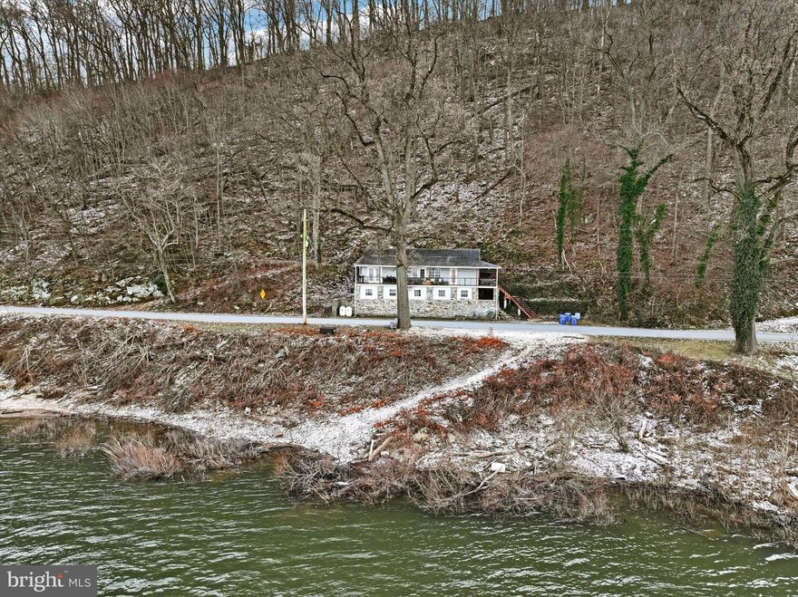 Welcome to this charming and serene riverfront property, perfect for a peaceful retreat or permanent residence. This unique offering includes  4.84 private, wooded acres, and features a fully functioning Air B&B for an excellent income opportunity.

The property offers private river access with a boat ramp and breathtaking views of the Susquehanna River, which can be enjoyed from the wrap-around mahogany porch. Relax in the hot tub while taking in the stunning sunsets over the water. This home is completely move-in ready, featuring a bright and open layout with hardwood flooring throughout.

The main level offers two bedrooms, a full bath, and an open-concept living, dining, and kitchen area with direct access to the front porch, making it perfect for entertaining. The lower level adds more space for guests with a wet bar/kitchenette, gaming table, an additional bedroom, and a remodeled luxury full bath. The original stone foundation adds character to the entire lower level, preserving the home’s unique charm.

This riverfront retreat is truly exceptional, combining tranquility, comfort, and income potential. Seller financing is available, making this a rare and desirable opportunity!
