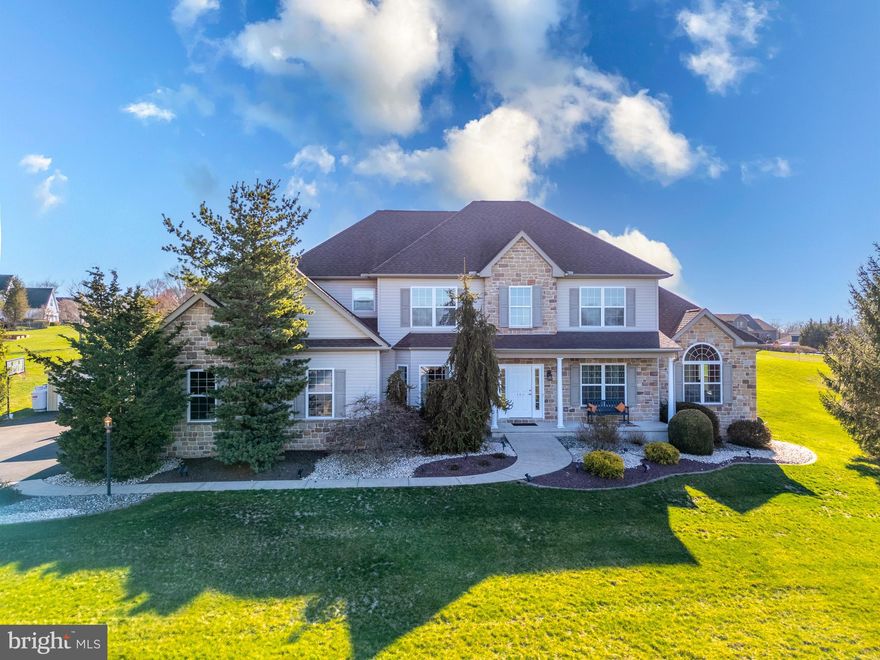 GeorgeAnn Custom Colonial — Fox Ridge Farms, Bushkill Township | Nazareth School District
Immaculate 5-bedroom, 3.5-bath custom colonial constructed in 2007 and situated on over one acre in the highly sought-after Nazareth School District. This GeorgeAnn-built masterpiece offers over 4,000 square feet of finished living space and showcases exceptional craftsmanship throughout, including detailed trim work, tray ceilings, rounded columns, wrought iron spindles and a grand center foyer that sets the tone from the moment you arrive.
The heart of the home is a stunning eat-in kitchen appointed with granite countertops, stainless steel appliances, a double oven and an oversized center island, all open to a bright morning sunroom and spacious family room. The family room impresses with soaring vaulted ceilings and a stone-front propane fireplace, while the sunroom opens to a private patio and custom in-ground pool surrounded by professional landscaping.
A rare and highly desirable feature of this home is the main-level bedroom  suite, offering a generous walk-in closet and a beautifully appointed private bath complete with a jetted tub and walk-in shower — perfect for single-floor living, multi-generational households or a luxurious home office alternative. The second floor delivers an additional master suite with a large walk-in closet and an oversized bath also featuring a jetted tub and walk-in shower, accompanied by three generously sized bedrooms and a full hall bath. The fully  finished basement with carpet and drop ceiling provides excellent additional space for a recreation room or hobby area.
Outside, the backyard is a true private haven with a custom-built swimming pool, a spacious paved patio and a level yard extending behind the pool — ideal for entertaining or play. A covered front porch with breathtaking views and a 3-car garage complete this exceptional property. Conveniently located near Routes 33, 78, 80 and the Pennsylvania Turnpike. This is a must-see home that truly has it all.