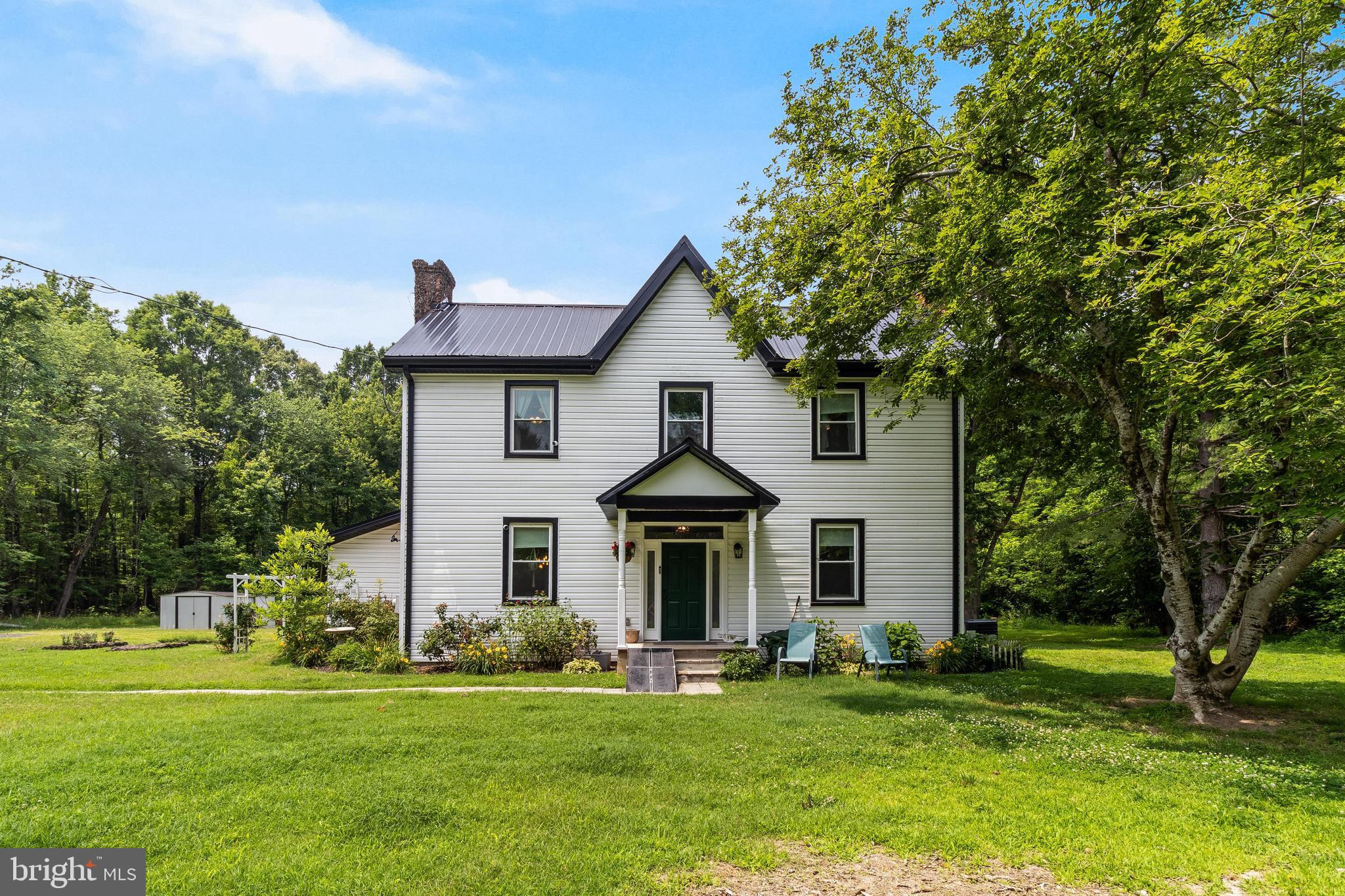 Step into a piece of history with this beautifully updated 120-year-old farmhouse that blends timeless character with modern comfort. Thoughtfully renovated, this home features classic touches like a farmhouse sink, shiplap walls, a charming staircase to the attic, and a cellar—all surrounded by mature shade trees that offer privacy and a picturesque setting. Inside, you'll find a flexible layout with 3–4 bedrooms and 2.5 bathrooms. The main-level primary suite option includes a spacious bedroom off the kitchen, a large closet with laundry, and a private full bath—perfect for single-level living. Alternatively, this space could serve as a cozy family room with convenient access to a large bathroom and combined mudroom/laundry area. The kitchen is both functional and full of personality, featuring granite countertops, stainless steel appliances, a built-in bench, and open shelving that displays vintage glass bottles found on the property. Adjacent is a welcoming living area with a fireplace that could easily serve as a formal dining space. Upstairs, you’ll find three generously sized bedrooms, a full bathroom, and access to an attic offering plenty of storage or potential to finish for more living space. Outside, a newly added patio area creates the perfect spot for outdoor entertaining or relaxing evenings under the trees. Nestled just off Rock Point Road and located in a sought-after school district, this one-of-a-kind property is ready to become your next home.