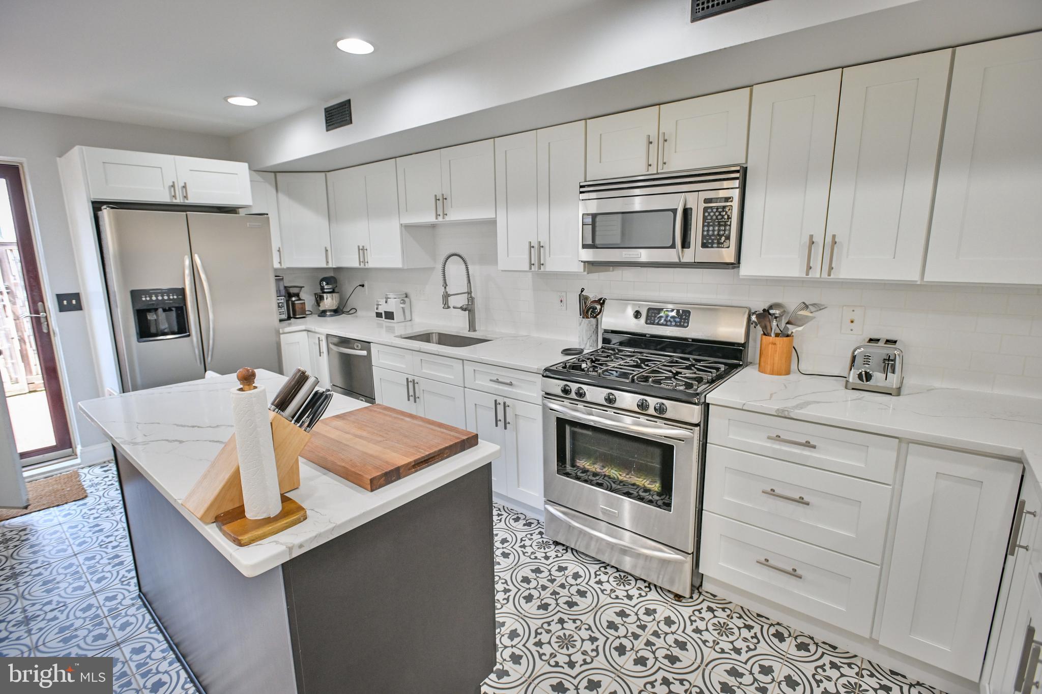 Welcome to 2216 E Lombard Street, a charming, renovated home in the heart of Historic Butcher's Hill with 3 bedrooms, 3.5 bathrooms, rear patio, rooftop deck, and 1 car parking!. This historic rowhome offers a combination of classic elegance and modern amenities, making it the perfect place to call home.
Upon entering, you'll be greeted by a bright and airy living room with hardwood floors, tall ceilings, crown molding, and recessed lighting. The open floor plan seamlessly connects the living room to the dining area, creating an ideal space for entertaining family and friends. There is also a conveniently located powder room on this level as well.
The kitchen has been tastefully renovated with sleek quartz countertops, tile floors, stainless steel appliances, and ample cabinet and counterspace. Whether you're a seasoned chef or just enjoy cooking the occasional meal, this kitchen will exceed your expectations. Off of the kitchen is access to the rear fenced brick patio where you can enjoy outdoor gatherings or a morning cup of coffee. Through the rear gate is access to a spacious 1 car parking pad! The unfinished basement is off of the side of the home through Bilco doors. This dry basement is perfect for storage.
Upstairs, you'll find three spacious bedrooms with hardwood floors, each offering comfort and privacy. On the 2nd level of the home are two of the three bedrooms, including the first primary bedroom with walk-in closet and en-suite bathroom with a and glass enclosed shower. The 2nd bedroom with large windows, has tons of closet space The updated hall bathroom with tub/shower combination showcases modern fixtures and a relaxing atmosphere. Also on this level is the stackable washer/dryer.
On the top level of this home , you will find the 3rd bedroom, which also serves as the 2nd primary bedroom. This room has hardwood floors and an en-suite bathroom with a soaking/jetted tub and glass enclosed shower. Access to the large, multi-tiered deck with awesome city and and water views is from the hall way on this level.
This home is 1.5 blocks away from Patterson Park and conveniently located to Johns Hopkins medical campys and area bars and restaurants. Don't miss the opportunity to make this delightful Baltimore residence your own. Schedule a showing today and experience the charm and convenience of 2216 E Lombard Street.