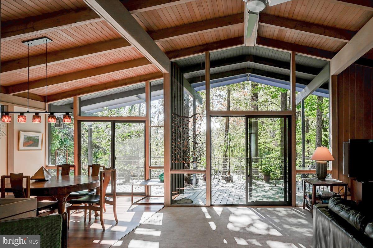 A stunning Mid-Century Modern home with POOL on 1.5 acres with 4BR/ 3.5 Baths, located in The Terraces, a hidden garden-like neighborhood in Mount Washington only minutes to downtown Baltimore. Floor to ceiling glass provides views of the surrounding trees, set within acres of woods- you would never know you're in the city! Open concept living and dining rooms feature a beamed cathedral ceiling, a large stone fireplace and a huge skylight makes this home very bright. Two sliding glass doors in the living and dining rooms open to an oversized deck overlooking the private in-ground pool and trees. The renovated kitchen will delight you with custom fused glass countertops and a large granite island, new stainless appliances including a Wolf cooktop and quiet Bosch dishwasher, and warm solid wood cabinetry. The original MCM kitchen design was retained including the unique glass above the cabinetry and the oversized windows that view a wall of blooming white azaleas in the springtime. The primary bedroom has 13 windows promoting true relaxation amid the peaceful green views, a walk in closet and a jetted tub in the renovated ensuite bath. Two additional bedrooms enjoy oversized windows with beautiful vistas and share a hall bath. An in-home office with original built-in shelving features its own oversized sliding glass door and balcony with wooded views. Brazilian Kempas hardwood floors offer a warm feel in the kitchen, dining room and foyer. The full daylight lower level features a family room with fireplace surrounded by glass and green views. A very large fourth bedroom with room for a living area, offers a private exterior entrance and has a walk-in closet and a full bath with a step-in onyx tiled shower. A kitchenette provides opportunities for use as a private au pair or in-law suite. Step outside the family room to enjoy the hot tub or cool off in the swimming pool ringed by tall trees for ultimate privacy- this is a true Urban Oasis! All of the original MCM design has been retained, while thoughtful updates have been made both indoors and on the exterior, including the roof, gutters, deck, sliding doors, some windows, both skylights, retaining walls and steps to the pool. A special feature is the city/county line that passes through this property making families eligible to attend either school system (buyer to verify). This home has only had three owners and was last on the market in 2006. Will you be the next trustee of this architect built gem? All original blue prints convey with the home. Furnishings are negotiable.