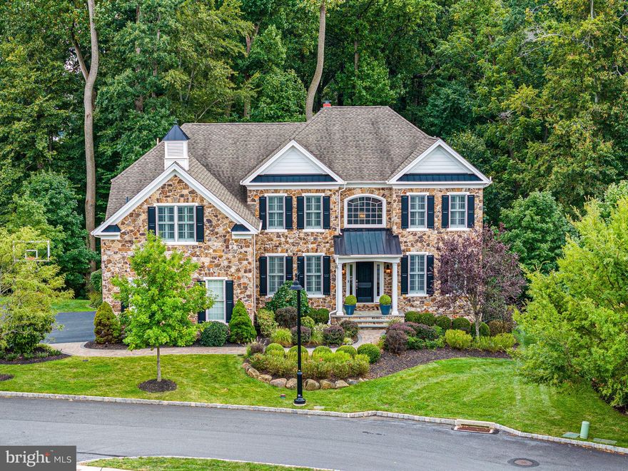 Welcome to this stunning home in the highly desirable, award-winning community of Liseter. Crafted with meticulous attention to detail, this Duke Model boasts a prime location, offering serene views of a lush preserve. A grand stone front elevation, enhanced by upgraded exterior lighting and manicured landscaping, sets the stage for the exceptional interior. Upon entering through the welcoming 2-story foyer, adorned with a graceful, curved staircase, guests experience an ambiance of refined elegance. Sunlight streams through expansive windows, illuminating the rich hardwood floors, complemented by plantation shutters, designer lighting, and exquisite millwork courtesy of Cocoon Design. Entertain in the sophisticated dining room with tray ceiling or unwind in the generously proportioned living room. The heart of the home, the gourmet kitchen, is a culinary delight, featuring premium cabinetry, a spacious island with beverage fridge, and Wolf Gas Range. A delightful breakfast room overlooks the lush backyard oasis, opening to an expansive Trex deck with pergola, perfect for al fresco gatherings. The family room exudes comfort and charm, boasting a gas fireplace with stunning stone surround and Pennsylvania Reclaimed Wood Beams. A private study with built-ins offers a tranquil retreat, while a remodeled powder room and custom mudroom enhance convenience on the main level. Hardwood floors grace the 2nd floor hallway, offering views of the main level below. The luxurious owner's suite beckons with hardwood floors, dual walk-in closets, and a spa-like bath featuring a soaking tub and a spacious shower. Additional guest bedrooms, including one with en-suite bath, provide comfort and privacy for family and visitors alike. The finished basement offers endless entertainment possibilities, with a game room, gym, and a stylish bar opening to a stone patio and impressive fireplace. Completing this remarkable home is an oversized 3-car garage with specialized Epoxy flooring, an outdoor irrigation system, and an invisible fence. Impeccably maintained, this home promises a lifestyle of luxury and leisure within the amenity-rich Liseter community, boasting a clubhouse, infinity pool, gym, tennis and pickleball courts, and scenic walking trails.