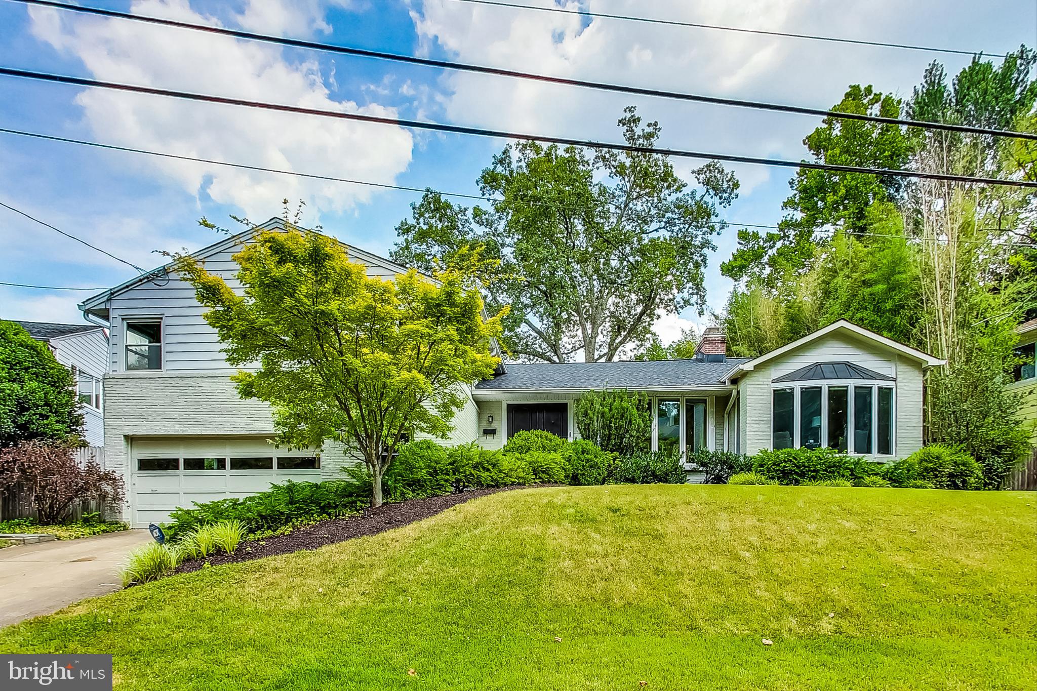 Nestled in the prestigious neighborhood of Rollingwood Chevy Chase, this elegant and modern residence offers more than meets the eye. Boasting over 4000 square feet of finished living space, this captivating home features 4 bedrooms and 3.5 bathrooms, providing ample space for comfortable living and entertaining. Upon entering, you are greeted by an abundance of natural light sprawling across the open floor plan. The living room and dining room offer beautiful views out of the front and back of the home, surrounded by lush landscaping. Not to mention a separate office for work from home space. An added wing offers flexible uses as a second work from home space or a playroom. Carefully tucked away is the powder room. The well-appointed kitchen is spacious and perfect for a cook of all skill levels. Not to mention it opens onto the back patio, garden, and yard, offering a serene retreat for outdoor enjoyment. Don't miss the au pair suite with its own bedroom and private full bath with glass shower door. The upper level hosts the primary suite including a renovated master bath with marble surround, along with two additional bedrooms and a renovated hall bath. The finished basement provides versatile space for recreation or relaxation. The owner has meticulously maintained the interior and exterior including a new roof. The backyard is a true gem, featuring a large slate patio that beckons you to relax and entertain. Multiple entrances to the house make indoor-outdoor living a breeze, while the lush gardening creates a picturesque setting for your morning coffee or evening cocktails. Notable other amenities include a dedicated laundry room, two car garage, and within a quick walk to Rock Creek Park and its ball fields, trails, playgrounds (including Candy Cane and Meadowbrook parks) and more. Situated on a generous lot, this residence epitomizes gracious living in a coveted location. Swing by the Brookville market, jump on Beach drive to go into DC, or visit the Meadowbrook stables all within minutes. Experience the allure of this remarkable residence by scheduling a showing today and make this captivating home your own peaceful retreat in the heart of Chevy Chase.