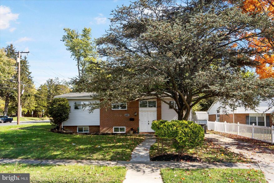 Beautifully maintained 5BR/3BA  split foyer Ranch situated on a large corner lot in the desirable neighborhood of Pikesville.  A beautiful shade tree welcomes you as you park in the driveway and make your way past green lawns to the doors of your forever home.  A brick facade surrounds the double entry doors featuring a large transom window above allowing for an abundance of natural light as you step inside.  Vaulted ceilings carry up to the main floor boasting gleaming hardwood floors, a bright and airy open concept flow from the living room into the dining room.  A newly remodeled kitchen boasts plenty of cabinets, stainless steel appliances, stunning granite countertops with a subway tiled backsplash, and a deep stainless sink under a window. The hardwood flooring and vaulted ceiling continue into the bedrooms which includes two sizable secondary, a large primary with his/hers closets and a private full bath with walk-in shower. On the lower level is two additional bedrooms, a full bath with walk-in shower, laundry, storage, and a large family room with space for everyone to enjoy.  From the dining room step outside to a patio and a fenced yard filled with tons of green space and possibilities.  This home is move-in ready with so much to offer new homeowners and is located within close proximity to shopping, restaurants, and commuter routes.