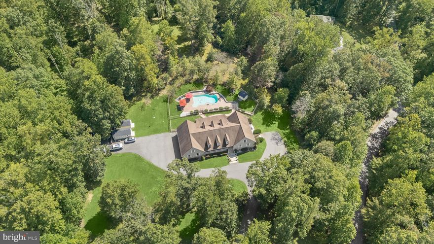 Discover the charm of this stunning sanctuary nestled on over 11acres that offers both tranquility and a convenient location close to every amenity imaginable. With 6 spacious bedrooms and 5.5 bathrooms, this residence is thoughtfully designed offering endless lifestyle options that include three main-level bedrooms, two upper-level bedrooms and a well-appointed apartment in the lower level with a second full kitchen and private entrance to the side car park area.
The heart of the home features a sizeable family room defined by architectural columns, a central fireplace, and built-ins that transition seamlessly into an open plan and dining room.  Adjacent to the dining and family rooms, the gourmet chef's kitchen stands at the ready for food prep complete with  an island, upgraded countertops, walk-in pantry, professional appliances, gas cooking and an inviting peninsula breakfast bar. Gleaming hard wood floors and natural light stream  from room to room in an open floor plan design and through windows treated with upscale plantation shutters. 
Outside, a retreat like oasis awaits with a heated, saltwater pool, water fountain and diving rock surrounded by multiple  stamped concrete patios, paver garden beds, and lush landscaping including pear, apple and plum trees. In addition to professional landscaping, there is a fenced dog run, pool shed with electric service, generator, and two machine sheds.  The oversized three car side loading garage offers upgraded 210-electic service, a work bench, two closets,  a rear service door, and an epoxy floor.
A wooded backdrop of trees and scenic vistas encircle this gorgeous 11.29-acre property where nature and equestrian pursuits are welcome.   With its endless lifestyle options, glistening saltwater pool and picturesque views all around, this home is a perfect blend of luxury, relaxation, adventure and outdoor living.  This home is not just a residence; it is truly a sanctuary!