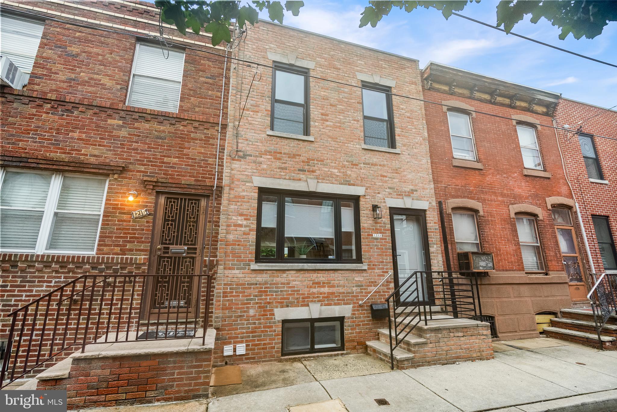 Exceptional Residence in East Passyunk! This distinctive home offers a rare feature—a fully full to ceiling glass rear wall and door that provide direct access to the back yard and floods the interior space with an exceptional amount of natural light. This custom renovation creates a modern, open, and sophisticated living space. Interior highlights include a gourmet kitchen with a center waterfall style island (on both sides), Calcutta quartz countertops and backsplash, and high-end stainless steel appliances, including a double-door refrigerator, gas cooktop, double oven, dishwasher, and range hood. The entire residence features hardwood flooring, offering a seamless and elegant aesthetic. The spacious living and dining areas are complemented by the impressive glass wall, enhancing the home's bright and inviting atmosphere. The rear yard provides a private outdoor space perfect for relaxation and entertaining. The finished basement offers ample recreational space, including a half bath, washer/dryer, and mechanical room, adding both functionality and comfort. The basement also includes a built-in air circulator which pulls the old air out of the space. Upstairs, the second floor comprises two generously proportioned bedrooms with ample closet space, along with two fully tiled, beautifully appointed bathrooms with highend Toto toilets. A skylight enhances the natural lighting, further contributing to the home's bright ambiance. Additional amenities include central air conditioning, radiator gas heating, and a desirable East Passyunk location. Conveniently located close to public transportation, the airport, the stadium district, parks, major highways, center city Philadelphia, East Passyunk Avenue and so much more! This unique property represents a superb opportunity—schedule your showing today.