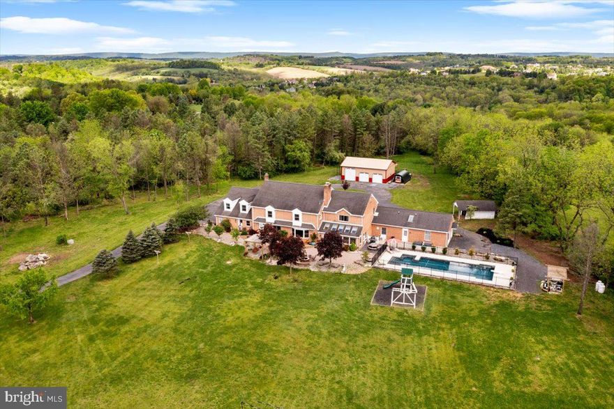 Escape the ordinary and step into the extraordinary with this 11 acre estate nestled on the outskirts of town. With 8800 square feet, this residence offers a lifestyle of unparalleled comfort and sophistication. Boasting 6 bedrooms, 6 full bathrooms, and 2 half bathrooms, there's ample space for everyone to spread out and relax. Inside, the ambiance is warm and inviting, with 3 cozy fireplaces nestled throughout the home. Step into the heart of the home, where culinary dreams come to life. The expansive kitchen, a true culinary haven, is meticulously designed for both form and function. Glistening stainless steel appliances harmonize with the warm tones of cherry cabinets, culminating in a space that seamlessly blends elegance with efficiency. Equipped with state-of-the-art technology, cooking and entertaining become effortless, solidifying this kitchen as the beating heart of the home. This home is not just a residence; it's a sanctuary filled with amenities. A versatile in-law suite with its own entrance and Aupair space offers flexibility for multi-generational living. The fully finished basement is an entertainer's paradise, complete with a full bar, theater with surround sound, billiard room, and full bath. Park your vehicles with ease in the 3-car attached garage or the additional 3-car detached garage, providing plenty of room for your prized possessions. For those with a passion for animals, this property comes with 4 outbuildings perfect for accommodating your furry friends. Step outside to your private oasis, where a saltwater pool awaits, offering endless hours of relaxation and rejuvenation. Host summer soirées on the patio, complete with a fire pit and tranquil water feature overlooking the meticulously landscaped grounds.