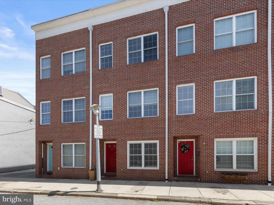 Nestled in the vibrant and sought-after community of Locust Point, this elegant three-level rowhome offers a refined blend of style, comfort, and versatility with three bedrooms and two-and-a-half bathrooms. From the moment you step inside, tall ceilings, an abundance of natural light, and a welcoming neutral color palette create a sense of openness and sophistication throughout the home. The entry-level living room immediately impresses with a bold statement accent wall, setting a modern tone and inviting atmosphere. Upstairs on the main level, rich hardwood floors and detailed crown molding add character and warmth. The thoughtfully designed kitchen is the heart of the home, boasting stainless steel appliances, granite countertops, white shaker-style cabinetry, a classic subway tile backsplash, and a large center island with stylish pendant lighting. A balcony just off the kitchen is the perfect setting for enjoying morning coffee or dining under the stars. The dining area is ideal for entertaining, while a convenient half bath and third bedroom provide flexibility. The top floor is dedicated to rest and relaxation, featuring two private bedroom suites. The primary suite is a serene retreat with a spacious ensuite bath offering a dual vanity and tub-shower combination. Step out onto the second balcony, where a spiral staircase leads to a rooftop oasis—an ideal escape for lounging, entertaining, or simply enjoying sweeping city views. The second upper-level bedroom is equally inviting with its own private bath featuring a walk-in shower. A tucked-away laundry closet adds convenience to the upper level’s thoughtful layout. Completing the home is an unbeatable location and rare parking flexibility, including a private garage, driveway, and additional off-street alley access. With its seamless blend of contemporary finishes, functional layout, and prime Locust Point location, this home is the perfect urban haven.