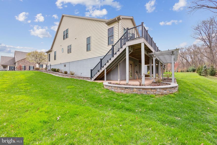 This is the best VALUE for the combination of the most desirable lot, large square footage, and location in the community! Prepare yourself to be impressed! This home shows like a model and the private lot can not be beat! Totally refreshed with thoughtful upgrades and exquisite details, if you're seeking to move to a 55+ community without sacrificing the features and space of a single-family residence, look no further. The size of this home is generous including areas for family gatherings, guest accommodations, a home office, entertainment and hobbies. Enjoy spectacular views , space between neighboring homes and expansive outdoor spaces designed for relaxation and socializing.

Only an out-of-state move has made this pristine, like-new property available. As you arrive, you'll notice the evident pride of ownership in this meticulously cared-for home. Enter through the gracious foyer, where fresh paint, gleaming hardwood floors, custom window treatments, abundant recessed lighting, and elegant oiled bronze hardware welcome you.

At the heart of the home lies a grand,  modern open area, featuring a spacious kitchen with handsome, creamy cabinetry, exquisite quartz countertops, stainless steel appliances, a generously sized pantry, and an expansive center island, complemented by an inviting dining area, complete with a cozy gas fireplace and custom built-ins. This space seamlessly flows into the expansive Family Room area which expands out to a low-maintenance TimberTech deck with stylish black railings, overlooking serene trees and providing access to the private backyard.

Arched doorways add character as you proceed to the elegant first-floor primary suite. The primary bedroom features a beautiful tray ceiling with uplighting and a ceiling fan, a transom window, and a custom Closets By Design walk-in closet. The primary bathroom is spacious and bright, with an oversized shower, soaking tub, updated vanity and extra cabinetry. Another main floor room, enclosed by glass French doors, serves as a quiet home office or additional bedroom, accompanied by a full guest bathroom. A convenient laundry room and immaculate two-car garage complete the main floor.

Upstairs, you'll find a large open loft area, complete with its own bedroom, full bathroom, and a stupendous custom closet. This level is ideal for a live-in relative, guests, or as a separate area for quiet activities, reading, crafts, or an additional home office.

The lower level is a true showstopper, offering expansive space for entertainment and recreation. Handsome wood flooring leads you to a custom wet bar with a sink, wine and beverage fridges, custom cabinetry, and shelving. This area also features another gas fireplace, custom built-ins, and plenty of room to watch the big game or movies and enjoy family time. A separate room can be used as a guest bedroom, hobby room, or additional home office. There is another great full bath and two generously sized storage rooms completing the lower level. Step outside to the charming rear paver patio with a pergola, perfect for savoring the serene backyard views and sounds.

This home was constructed with upgraded landscaping and hardscaping, gutter guards, an enhanced exterior lighting package, sprinkler system, alarm system, and water softener, leaving no detail overlooked.

Located in the desirable Honeycroft Village community, residents enjoy access to a pool area, fitness center, bocce ball, horseshoes, a fire pit and community garden. With lawn care, snow removal, and trash services taken care of, you can move in and start enjoying life. Nearby, you'll find restaurants, farmers' markets, golf courses and shopping. Schedule your private tour today! Homestead exclusion could be applied for tax savings.