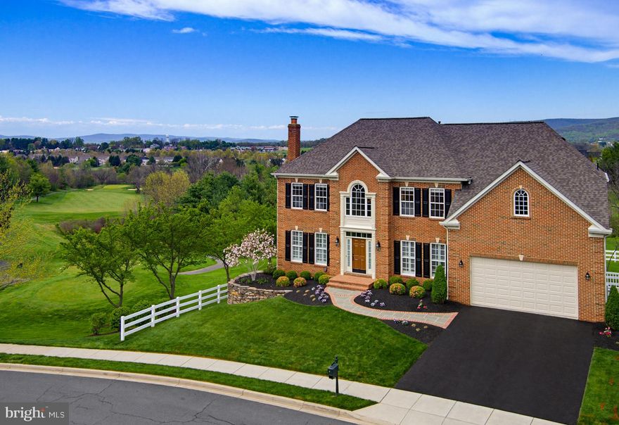 Set on a premier homesite in sought-after historic Middletown, Maryland, this distinguished residence offers nearly 6,800 square feet of refined living. Framed by panoramic mountain views and an exceptional golf course backdrop, the home captures serene vistas of the 15th and 16th fairways to the rear and a dramatic side exposure along the 17th hole, delivering a rare blend of privacy, openness, and resort-inspired elegance.

A slate walkway, stacked stone, and curated landscaping lead to a soaring two-story foyer with hardwood floors, detailed molding, plantation shutters, and an elegant chandelier. The home feels refined, welcoming, and thoughtfully designed.

The main living spaces balance elegance and comfort. A formal living room with a wood-burning fireplace offers a quiet place to unwind, while the dining room, finished with tray ceilings, wainscoting, and refined lighting, is ready for everything from intimate dinners to large gatherings. Throughout the home, a whole-house audio system allows music to flow effortlessly, creating an atmosphere that feels both relaxed and elevated.

The main level study, with custom cherry built-ins and golf course views, creates a workspace that feels private and inspiring. The two-story family room brings scale and comfort together with a coffered ceiling, custom wall detail, transom windows, and a gas fireplace. It is a space that feels just as right for quiet evenings as it does for hosting, with views of the course present from nearly every angle.

At the center of the home, the kitchen has been designed without compromise. Viking Professional Series appliances, custom cherry cabinetry, black honed granite, and a thoughtfully designed layout with dual sinks and a full butler’s pantry create a space that is as functional as it is impressive. Every detail, from instant hot and cold water to custom storage solutions, has already been considered. It is a kitchen built for both daily living and entertaining at a high level.

Just beyond, the morning room softens the pace of the day. Bright, open, and connected to the views, it turns ordinary moments into something more. Morning coffee lingers longer here. Breakfast feels calmer as the first light stretches across the fairways.

Upstairs, the owner’s suite offers a true retreat, complete with hardwood floors, a sitting room, two walk-in closets, and a spa-quality bath finished in travertine with dual shower heads, soaking tub, and high-end fixtures. Secondary bedrooms are equally well-appointed, with flexible layouts and refined finishes that make every space feel intentional.

The walkout lower level extends the lifestyle of the home, offering a fully equipped entertainer’s bar with GE Monogram appliances, a billiards area, guest suite, and a luxury bath. Whether hosting, accommodating extended stays, or creating a private escape within the home, this level delivers without compromise.

Outside, more than $100,000 was invested in a private outdoor setting. A custom stone patio, built-in KitchenAid grill, fire pit, fountain feature, and expansive walk-down deck create a true outdoor living experience.The property also presents excellent potential for a future pool, offering the opportunity to create a private resort-style outdoor retreat tailored to the next owner’s vision.

Beyond aesthetics, the home has been upgraded where it matters most. A newer roof in 2023 with a transferable warranty, updated Trane HVAC  with smart controls, professionally routed drainage, a security system, and a finished garage with epoxy flooring and modern access technology ensure that the next owner can simply move in and enjoy.

A rare combination of scale, setting, and refinement, this residence is thoughtfully appointed for effortless move-in and immediate enjoyment in the heart of historic Middletown.