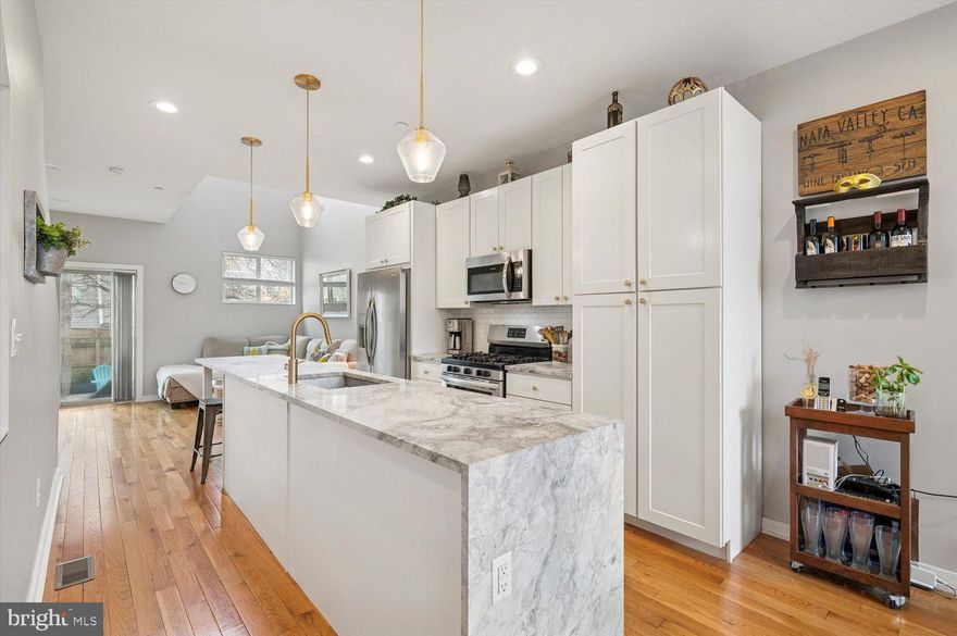 Welcome to 1933 E Cumberland, a stunning and thoughtfully designed rowhome that perfectly blends modern construction with timeless charm. Nestled in a quieter neighborhood yet just moments from the vibrant heart of Fishtown, this home offers the best of both worlds.

Step inside to an inviting open-concept floor plan featuring a spacious dining area, a sleek kitchen, and a living room with soaring vaulted ceilings. The kitchen is a chef’s dream, boasting a massive island, stainless steel appliances, and elegant white cabinetry. Expansive windows throughout the first floor flood the space with natural light, creating a warm and airy ambiance. Just beyond the living room, you'll find a true urban oasis—an oversized backyard perfect for fur babies or entertaining.

The second floor is dedicated to the luxurious primary suite, complete with a walk-in closet and a spa-like bathroom featuring double sinks and a glass-enclosed shower. A bright and airy landing on this level provides the perfect spot for a home office or reading nook.

Upstairs, the third floor hosts two generously sized bedrooms, each with ample closet space and large windows. A full bathroom and a convenient laundry room complete this level. Continue up to the expansive roof deck, where you’ll enjoy breathtaking views of Center City—ideal for unwinding or entertaining guests.

The fully finished basement adds even more versatility, offering additional living space and a full bathroom. With 4 years remaining on the tax abatement, this exceptional home truly has it all. Don’t miss your chance to make it yours!