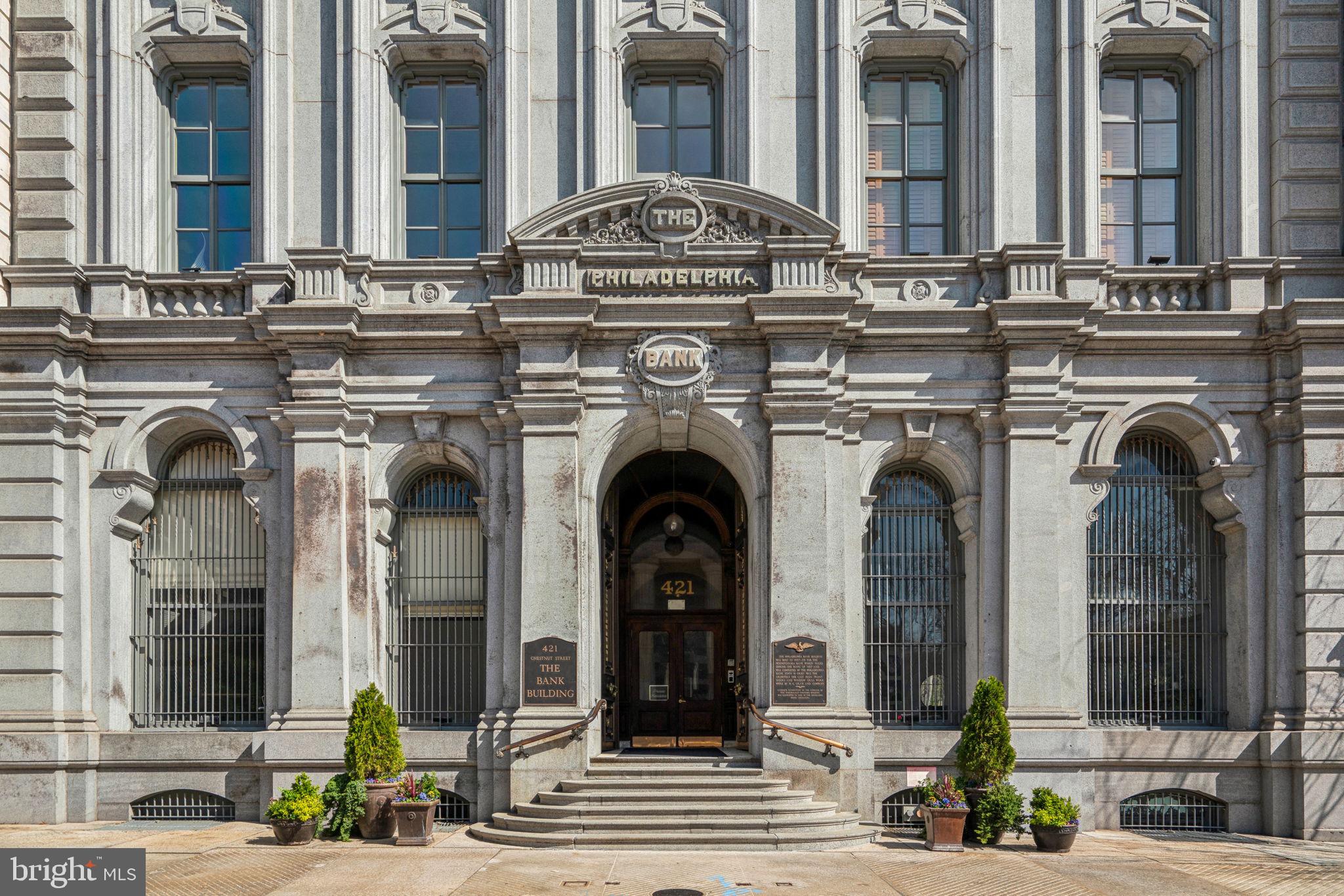Welcome to Unit 304 at 421 Chestnut St—a stunning 1,330 SF luxury condo in the boutique Bank Building, nestled in Philadelphia’s desirable Old City.
As you enter the elegant lobby, a doorman will warmly greet you before you take the elevator to this one-of-a-kind residence. Inside, the striking brick barrel-vaulted ceilings immediately capture your attention, adding depth and character to the space. The entire apartment was thoughtfully decorated by a New York interior designer whose remit was to make the look and feel reminiscent of the London private club Soho House.
The open-concept kitchen and living area are both chic and inviting—perfect for entertaining. The chef’s kitchen boasts high-end stainless steel appliances, granite countertops, an oversized island, and ample cabinet and pantry space. Flowing seamlessly from the kitchen, the living area features a gas fireplace with a custom copper textured surround, a built-in bar, and integrated surround speakers that fill the room with sound, complementing the stunning vaulted ceilings.
This condo offers two well-appointed bedrooms, each situated on opposite sides of the living area for optimal privacy. The primary bedroom is a showstopper, featuring a grand faux window, exposed brick, and a skylight that enhances the room’s depth and ambiance. It also includes a spacious walk-in closet with a custom organization system of shelves, rods, and drawers. The modern en-suite bathroom boasts a large walk-in shower and heated towel racks for a spa-like experience.
The second bedroom is equally impressive, with a custom closet system and a unique built-in, wall-to-wall bookshelf that doubles as a home office behind a sliding barn door. A second full bathroom features a Jacuzzi tub and heated towel racks. Conveniently located in the hallway, the washer and dryer are neatly tucked away in a designated closet.
Throughout the condo, exquisite textured wallpaper, thoughtfully designed storage spaces, and sophisticated finishes elevate the home’s aesthetic.
Residents enjoy exclusive access to the amenities of the adjoining hotel via an underground walkway, including a gym and lap pool at no extra charge. Additional hotel services—such as room service, guest accommodations, laundry/dry cleaning, and housekeeping—are available at a discounted rate. For parking, The Bourse Garage next door offers several convenient options.
Located in the heart of independence national park, the site of Independence Hall, the Bank Building is on the list of historic buildings in Old City, and sits directly opposite the Second bank of the United States. The building also benefits from being in the heart of Philadelphia’s best restaurants, bars, shops, museums, and historic sites.
Design-forward and impeccably maintained, this condo is truly a standout.
Schedule your showing today!