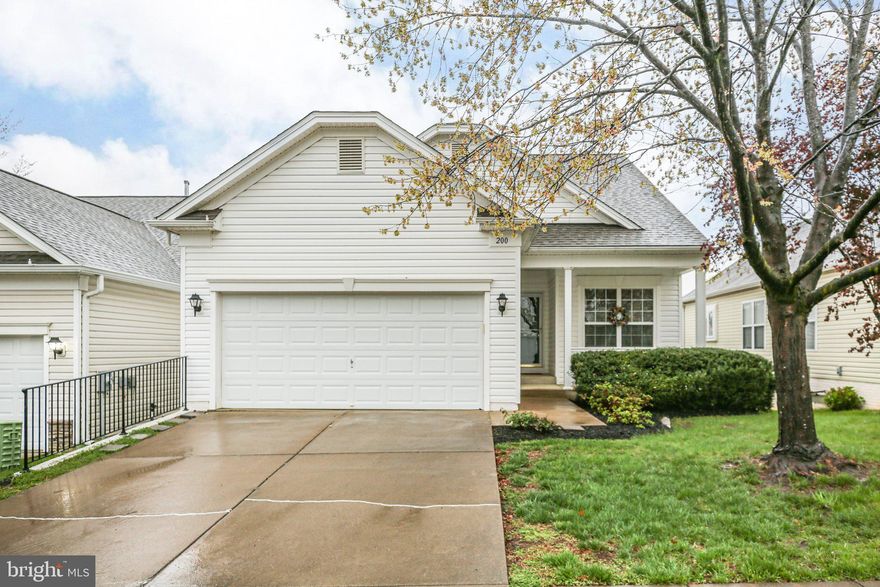 Welcome to this beautifully maintained James model in the sought-after Falls Run community—an active 55+ neighborhood offering low-maintenance living at its best. Thoughtfully updated, this home features a new roof (2022), fresh neutral paint throughout, and new carpet in all bedrooms and the finished basement.

Enjoy relaxing mornings on the charming front porch, or entertain in the spacious interior with gleaming hardwood floors and an open layout. The kitchen offers an extended space perfect for casual dining or a cozy desk area, with a convenient pass-through window to the formal dining area and a large, sunlit family room.

The main-level primary suite offers comfort and privacy with a walk-in shower, cozy heat lamp, and a huge walk-in closet with built-in shelving. A second main-level bedroom and full bath provide additional space for guests or hobbies.

You'll love the main-level laundry/mudroom just off the attached two-car garage, making daily tasks a breeze.

Downstairs, the fully finished basement includes a spacious rec room with built-ins, a third bedroom and full bath, plus a flex room ideal for crafts, a home gym, or storage. A walk-out sliding door leads to a private patio, and the unfinished storage area with sump pump is perfect for a workshop or seasonal items.

This home also features a newer refrigerator and washing machine, giving you peace of mind and move-in-ready convenience.