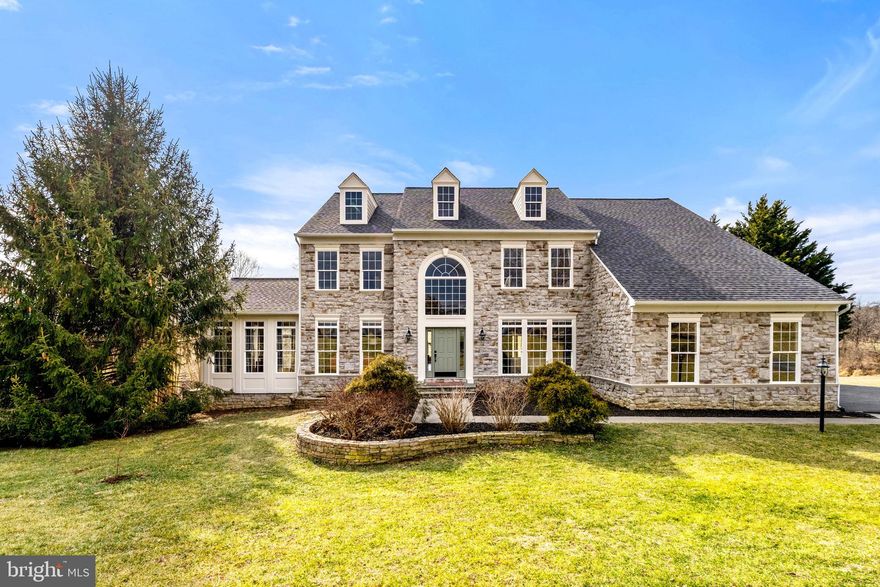 Welcome to 39054 Old Stage Place, a refined country retreat set on 4.2 gently rolling acres in the scenic countryside of Waterford, Virginia, accentuated by mature trees, a year-round creek, and a site carefully chosen to capture both sunrise and sunset vistas. The current owners are relocating and have invested nearly $100,000 over the past year to elevate an already exceptional property. A newly installed roof with a 20-year transferable warranty and freshly painted exterior create an elegant first impression, while the white oak–fenced 2.5-acre pasture provides both structure and versatility— with no HOA, this property is perfectly suited for equestrian pursuits, hobby farming, or outdoor recreation. An added third dormer enhances architectural balance while a freshly painted interior and updated fixtures bring a polished, contemporary feel to the home. Inside, 9-foot ceilings span all three levels, highlighted by a two-story curved staircase, hardwood flooring, and a spacious floor plan ideal for both intimate evenings and grand-scale entertaining. Thoughtful builder enhancements, including strategic bump-outs, create generously proportioned rooms. Upstairs, the second level features four spacious bedrooms and three full bathrooms, offering comfortable privacy for family and guests. The primary suite is a luxurious retreat, complete with a sitting room, his-and-her closets, a standing shower, and a soaking tub. The walk-out basement provides ample space for entertaining and guest accommodations. The main area is anchored by a custom live-edge bar, mini kitchen, and pellet stove, creating a warm, inviting atmosphere. The fifth bedroom and fourth full bathroom are also located in a quiet corner, along with plenty of additional space for hobbies, recreation, or home office use. Outbuildings further enhance the estate’s versatility: an oversized three-car garage, a 12’ x 20’ oak board-and-batten barn with sliding door, a garden shed, and a chicken coop with enclosed run — all supported by a dedicated 20-amp electric circuit. Enjoy easy access to Dulles International Airport (35 minutes) and downtown Washington, D.C. (60 minutes) while retreating to your private sanctuary. Just moments from the village’s historic charm, celebrated wineries, and scenic byways of Loudoun County, this distinguished colonial offers a rare blend of privacy, craftsmanship, and modern enhancements.