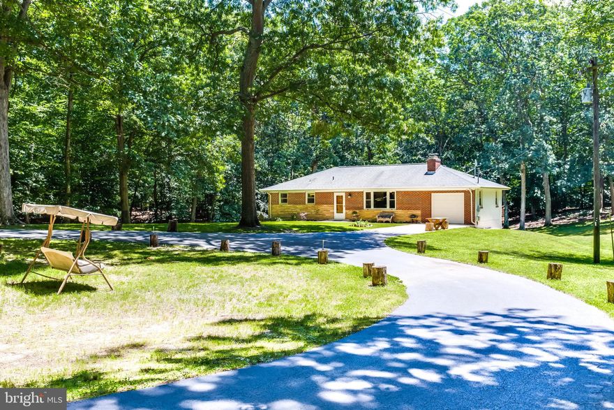 Long, paved circular driveway leads you to this beautiful ranch style home situated on a gorgeous private, secluded lot with 2.75 acres!! Over 2,000 sq ft of living space! The main level features 3 bedrooms and a full bath. Family room with a wood burning fireplace. Shining hardwood flooring throughout. The eat in kitchen has stainless steel appliances, including a wine fridge and a tile back splash. Enjoy your morning coffee with a beautiful view from the sunroom or upper deck. The basement is finished with a large rec room, additional room currently being used as a 4th bedroom and a full bath. Large utility room has washer and dryer and ample room for storage. Walk out to the open back yard where you have plenty of space for the kids to play or for entertaining on the patio or huge fire pit. This is the perfect spot to escape from the day to day grind but still close enough to shopping and restaurants with the town of La Plata only 5 minutes away! Also perfect for commuting with easy access to Rt. 210 and Rt. 301. You do not want to miss this opportunity!