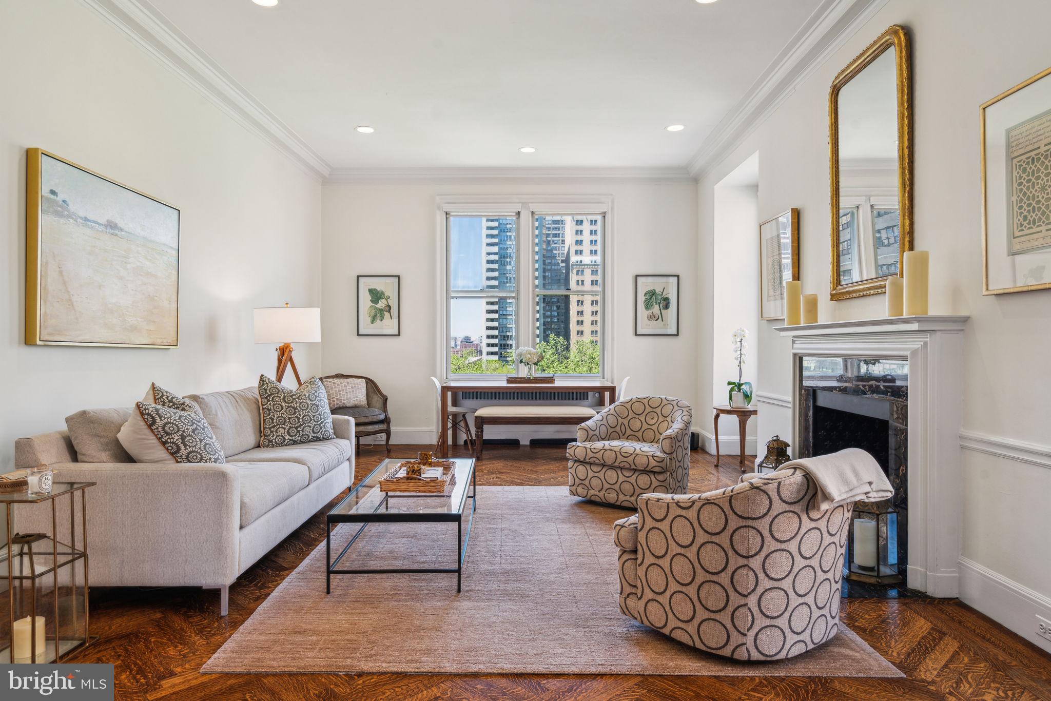 This spectacular residence is a rare offering—a three bedroom, two and a half bathroom showplace at the highly coveted Barclay Condominium that has been meticulously renovated while staying true to its many original architectural details. High ceilings, oversized windows with sunset views atop Rittenhouse Square, rich wood flooring, excellent entertaining space, custom built-ins, and a brand new chef's kitchen are only a handful of the luxurious highlights.
Enter through a foyer with coat closet into a central gallery boasting a domed ceiling detail with custom chandelier, ideal to be used as a formal dining room, entrance hall or other entertaining space. Past the gallery is the grand living room with two walls of tall windows offering views of The Square, a fireplace with marble surround, and a wall of built-ins framing a set of French doors that lead to the family room. The family room has ample space for a large sofa and chairs, as well as more oversized windows that stream in natural light and a built in desk nook. A powder room with hand painted mural and large window looking eastwards over the Saint Mark's church is also accessible from this space.
The fully renovated eat-in kitchen is truly a chef's dream. The center piece of the room is an oversized island with marble top, thoughtfully designed storage space, and large breakfast bar with seating for six. Other features include Berman and Bowen white shaker wood cabinetry including multiple display cabinets encased in glass with accent lighting, marble and butcher block counters, large Allia sink with garbage disposal and spray faucet, Shaws ceramic bar sink, built-in coffee bar with marble top behind cabinet doors, checkerboard Italian tile floor, and high-end appliances including a Sub Zero refrigerator, Miele dishwasher plus an additional Fisher and Paykel dishwasher drawer, Wolf commercial grade oven with six burner gas range and hood, designer tile backsplash behind the range, XO wine refrigerator, and built-in beverage drawers.
The luxurious primary suite enjoys more windows with Rittenhouse Square views, a large built-in entertainment center with closet/storage space, deep wall closet, and bathroom with marble tilework, modern white vanity and tub-shower with a tile accent wall. There are two additional bedrooms both with views of The Square and custom built-ins that enjoy a shared updated Jack-n-Jill bathroom. There is a private laundry room with a sink, storage space, and stacked GE Power Steam washer/dryer. The home is further enhanced with high-end hardware, recessed lighting and custom light fixtures, herringbone and parquet wood floor patterns, and crown and baseboard molding throughout.
Residents of The Barclay enjoy a twenty-four hour doorman, fitness center, chauffeur driven Mercedes, on-site management, and individually controlled heating and air conditioning. Stephen Starr’s Barclay Prime steakhouse is located on the building’s ground floor