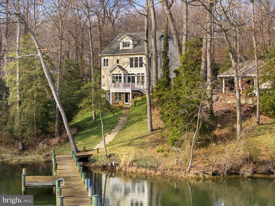 Nestled amongst the trees in the amenities rich Annapolis Roads community this 4 bedroom, 4.5 bath with 3,400 sq ft of living space has everything needed in a waterfront home! Discover the ultimate waterfront lifestyle with your own private pier on Lake Ogleton featuring 4’ MLW —providing seamless access to the Lake or out to the Chesapeake Bay for sailing, fishing, crabbing, or simply enjoying sunset cruises. Whether you’re an avid boater or just love the tranquility of the water, this property offers the best of both worlds. Inside, thoughtful details abound. The main level features a beautifully appointed kitchen and family room, enhanced with custom trim and crown molding, that opens onto a waterside deck—perfect for hosting gatherings or simply soaking in the views. Upstairs, the elegant primary suite offers water views, an elegant fireplace and a recently remodeled luxurious bath that feels like a spa retreat. Additional remodeled bathrooms throughout the home combine modern style with comfort. The versatile walk-out lower level expands your living space and could easily serve as a 5th bedroom suite, complete with full bath and wet bar—ideal for guests, multi-generational living, or casual entertaining after a day on the water. Set on a nature lover’s lot with lush plantings, the outdoor spaces invite you to relax in privacy while surrounded by beauty. Beyond your backyard, the community offers amenities that enrich the lifestyle: a Bayfront overlook with pavilion where neighbors gather, a playground, and scenic walking trails.  Located just minutes from downtown Annapolis and Eastport which offers the perfect balance of small-town charm and big world sophistication. Traveling or commuting is just as convenient by easily accessing Rt. 50 and 97 which provides direct access to Baltimore, BWI, Ft. Meade/NSA and Washington, DC., or head over the Bay Bridge to the Eastern Shore for a quick beach vacation. Welcome Home!