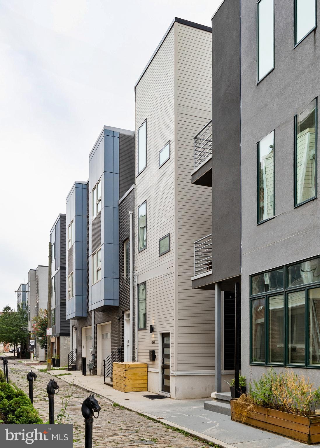 Tucked away on one of Northern Liberties’ most charming cobblestone blocks, 858 North Leithgow Street is a thoughtfully designed, architecturally significant home that’s truly one of a kind. Built in 2019, this contemporary 3 bedroom, 3 bathroom home makes a bold impact, with every inch of space carefully considered, with refined finishes, custom features, and an abundance of natural light throughout.
The main level features extra high ceilings and a warm, open design. The living area has a custom wood architectural element that rises from floor to ceiling, dividing the sitting area from the staircase and connecting the floors above and below the main level in a playful yet compelling way. The kitchen is flooded with light from clerestory windows above and includes a peninsula with barstool seating, sleek cabinetry with built-in conveniences (spice rack, refuse, lazy susans), and stainless steel appliances. Just off the kitchen, a private backyard patio offers the perfect setup for morning coffee, outdoor dinners, or casual gatherings.
The fully-finished lower level is a true extension of the home’s living space and includes a media room, a full bedroom, and a stylish open wet bath with tile floors and walls. Under a modern mantle in the media room, a fireplace with bioethanol heating adds a cozy touch and is included with the home.
On the second floor, an open office area leads to a second bedroom, laundry, and an elegant full bath. The third-floor primary suite includes excellent closet space, a stunning full bath with dual vanities, sleek black tile, and a dual-head setup in an oversize shower. The third floor also provides access to an interior courtyard area. This unique, gravel-floored indoor-outdoor space connects to a spiral staircase that leads up to the private rooftop deck.
The rooftop entertainment area is a true highlight, complete with a custom pergola and incredible views of Center City and the Ben Franklin Bridge. Whether you're entertaining or simply enjoying a quiet evening, this space is beautifully finished and easy to love.
Additional highlights include hardwood floors throughout, central air, tankless hot water heating, ceiling fans in the bedrooms and living room, sliding closet doors, and a custom refuse and recycling enclosure at the front of the home. Window treatments, light fixtures, kitchen appliances, washer/dryer, gas grill, and bioethanol fireplace are all included in the sale, and 5 years remain on full tax abatement!
This is not a typical row home—it's a smart, sophisticated space with tasteful design and creative use of every square foot. Every detail reflects the care, intention, and passion of the architect-owner who has brought to life a modern, warm residence as a model for urban living. Just steps from some of the best dining, coffee shops, markets, bars, and public transportation in Northern Liberties, 858 N Leithgow is a home you’ll love coming back to every day.